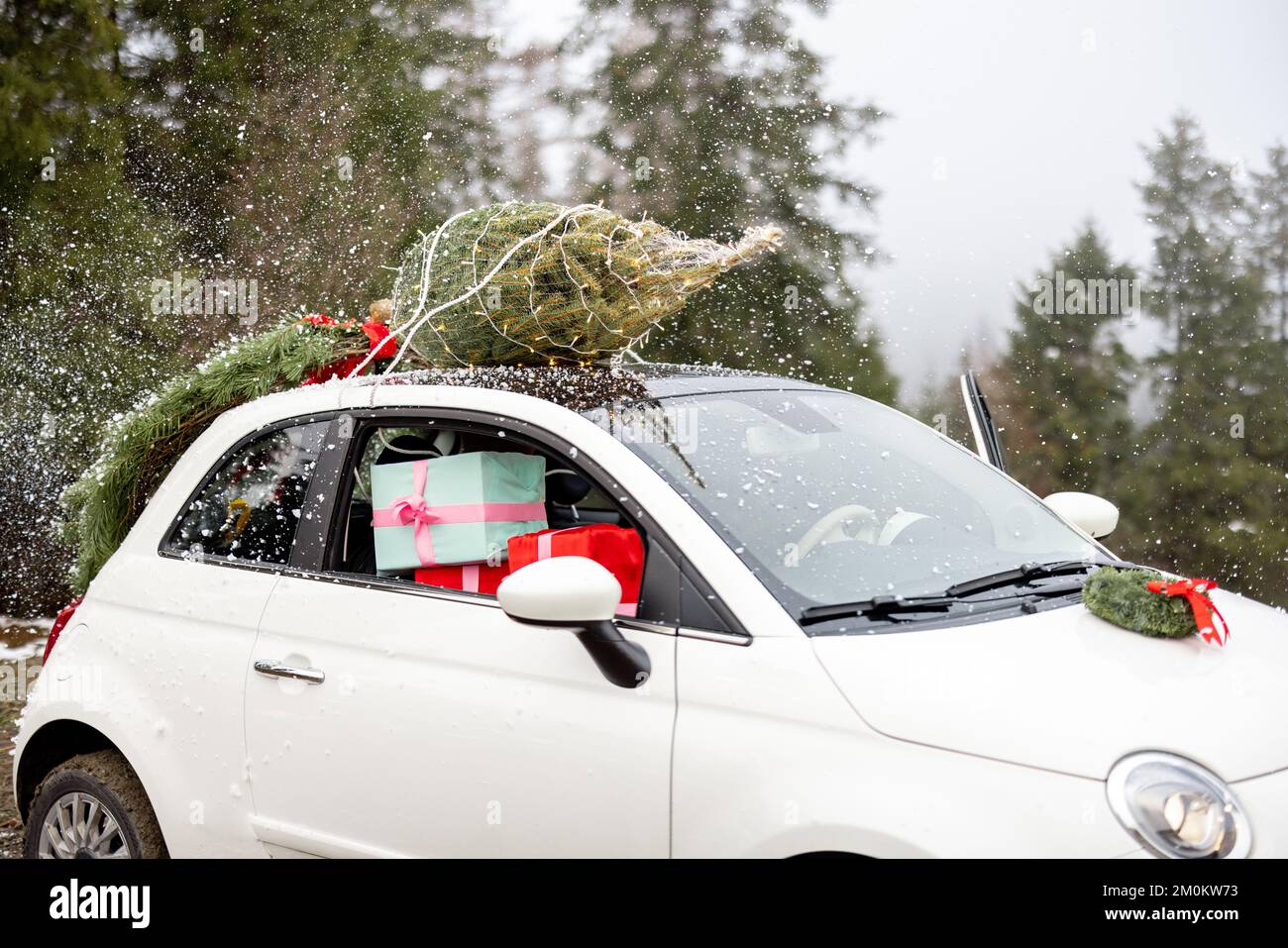 Auto mit Weihnachtsbaum auf dem Dach und Geschenken Stockfoto