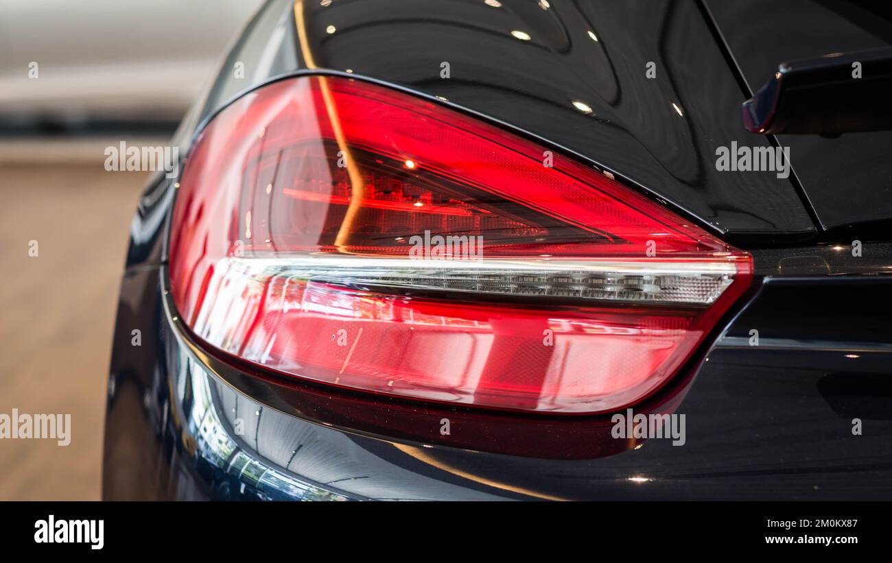 Eine Nahaufnahme des abgeschnittenen Porsche Cayman S Rücklichts verschwommener Hintergrund Stockfoto