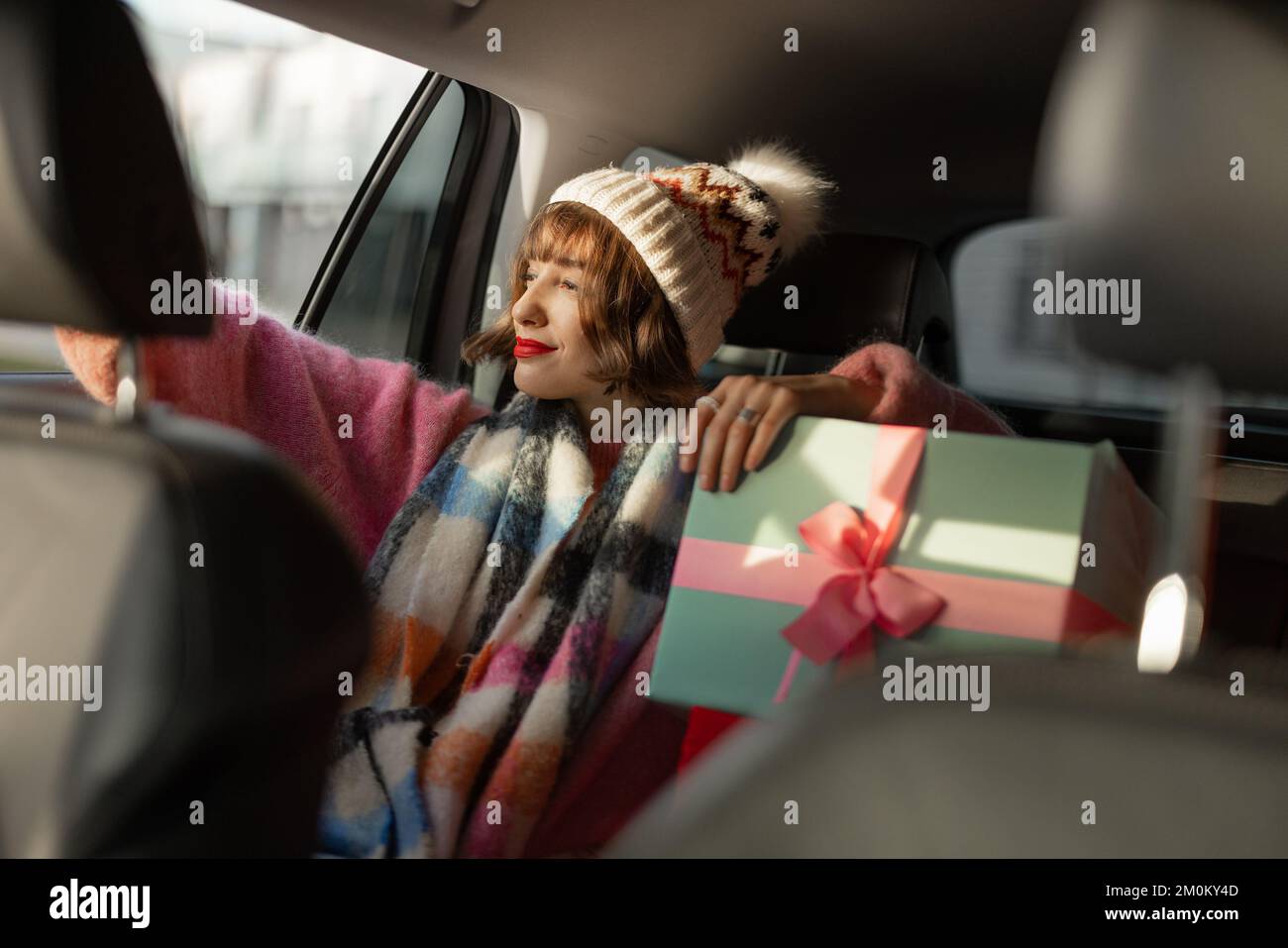 Frau im Auto mit Weihnachtsgeschenken Stockfoto