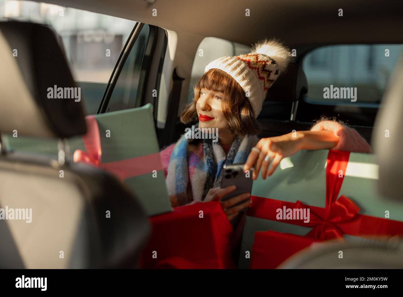 Frau im Auto mit Weihnachtsgeschenken Stockfoto
