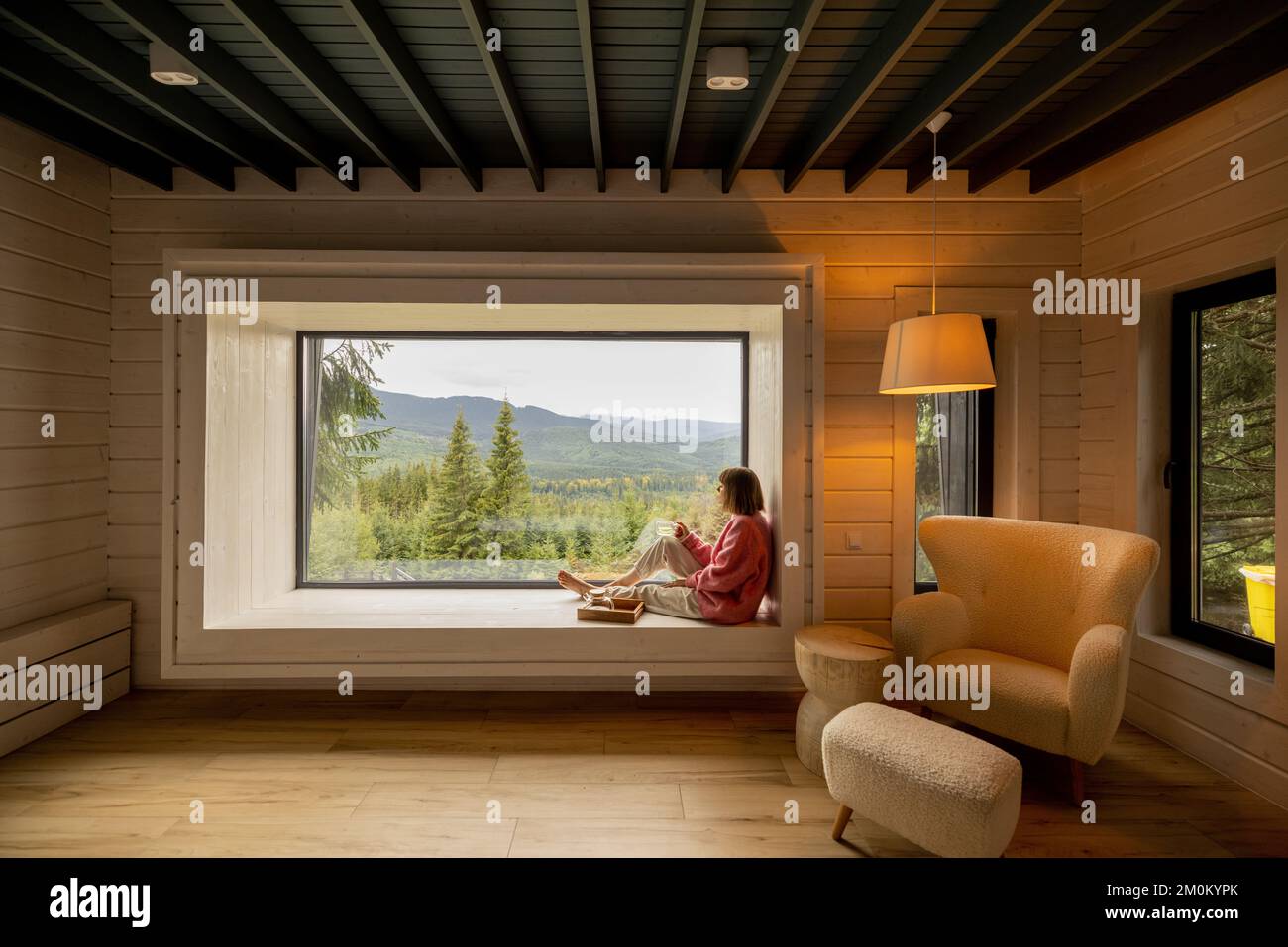 Frau ruht im Haus mit Panoramablick auf die Berge Stockfoto