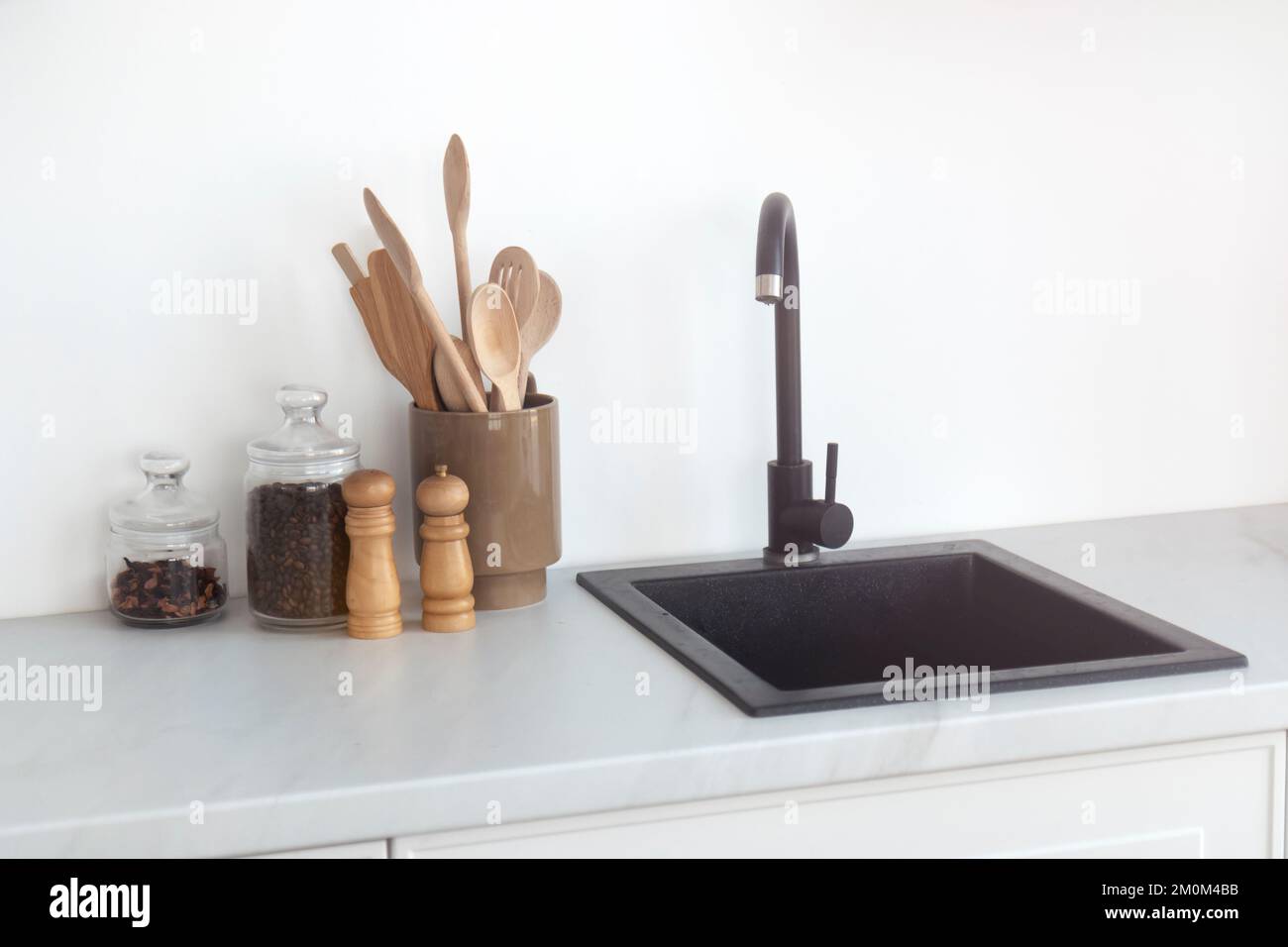 Minimalismus in der Küche, schwarzes Waschbecken und Wasserhahn Stockfoto