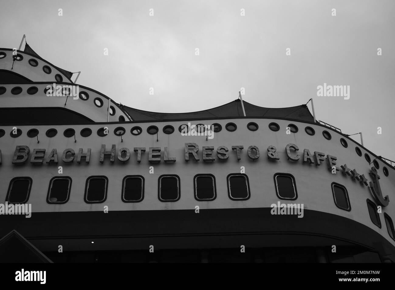 Pangandaran, Indonesien - 30. Oktober 2022 : Monochromfoto des Krisna Beach Hotels mit einzigartiger Form und einem Schiff auf dem Dach eines Gebäudes Stockfoto