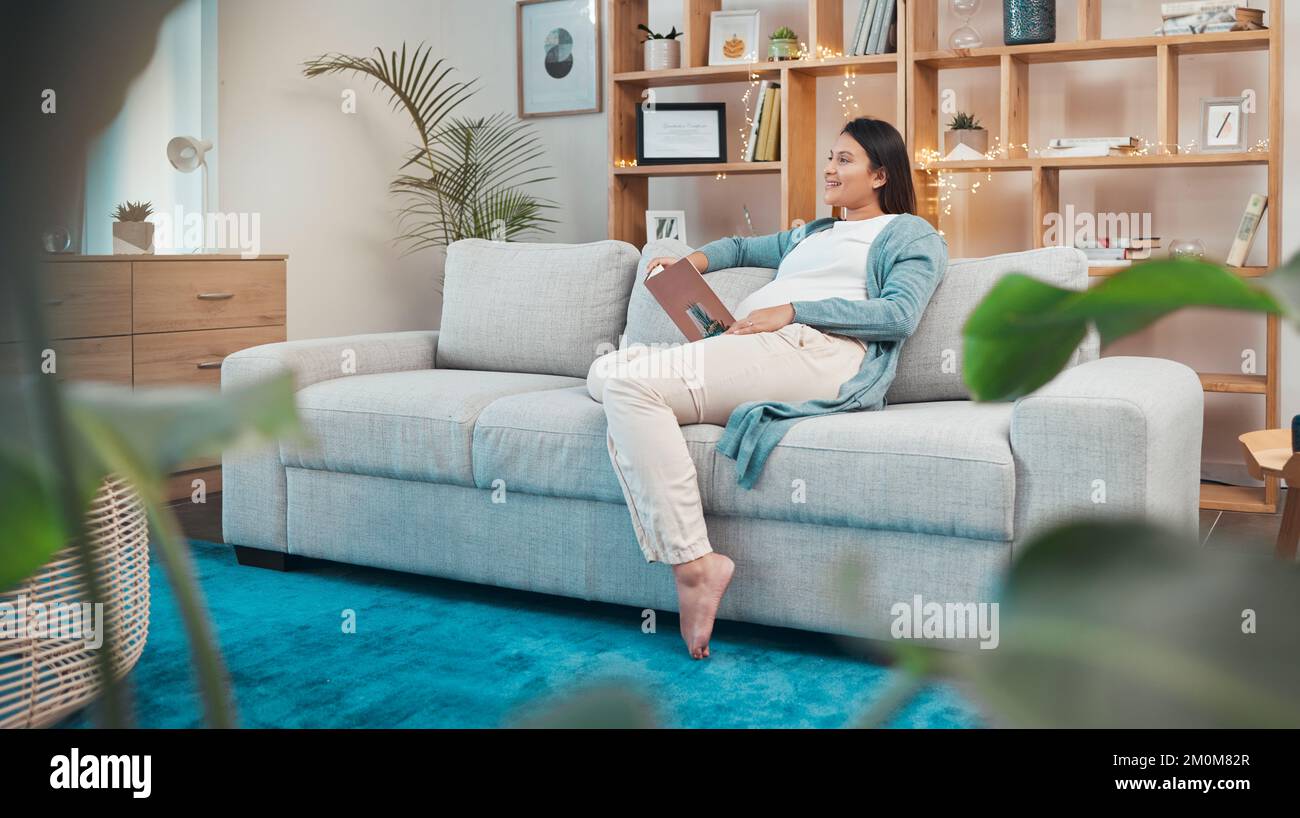 Schwangere Frau, entspannen Sie sich und lesen Sie zu Hause ein Buch auf dem Sofa, denken oder nachdenken. Schwangerschaft, Idee und Frau, die auf dem Sofa sitzt und Literatur studiert Stockfoto
