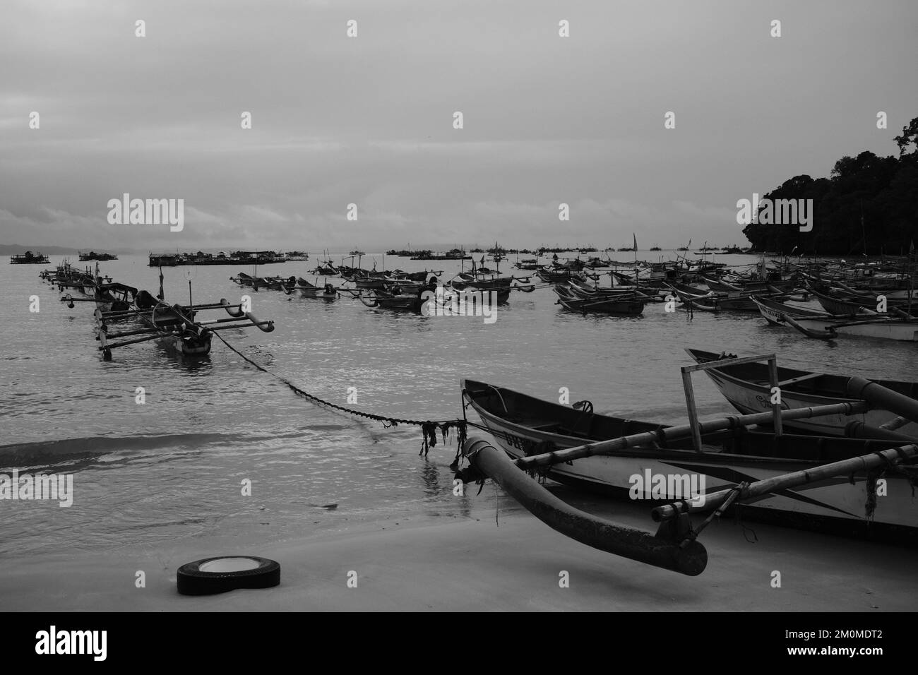 Schwarzweißfoto, Schwarzweißfoto einer Reihe von Fischerbooten am Strand in der Gegend von Cikancung - Indonesien Stockfoto