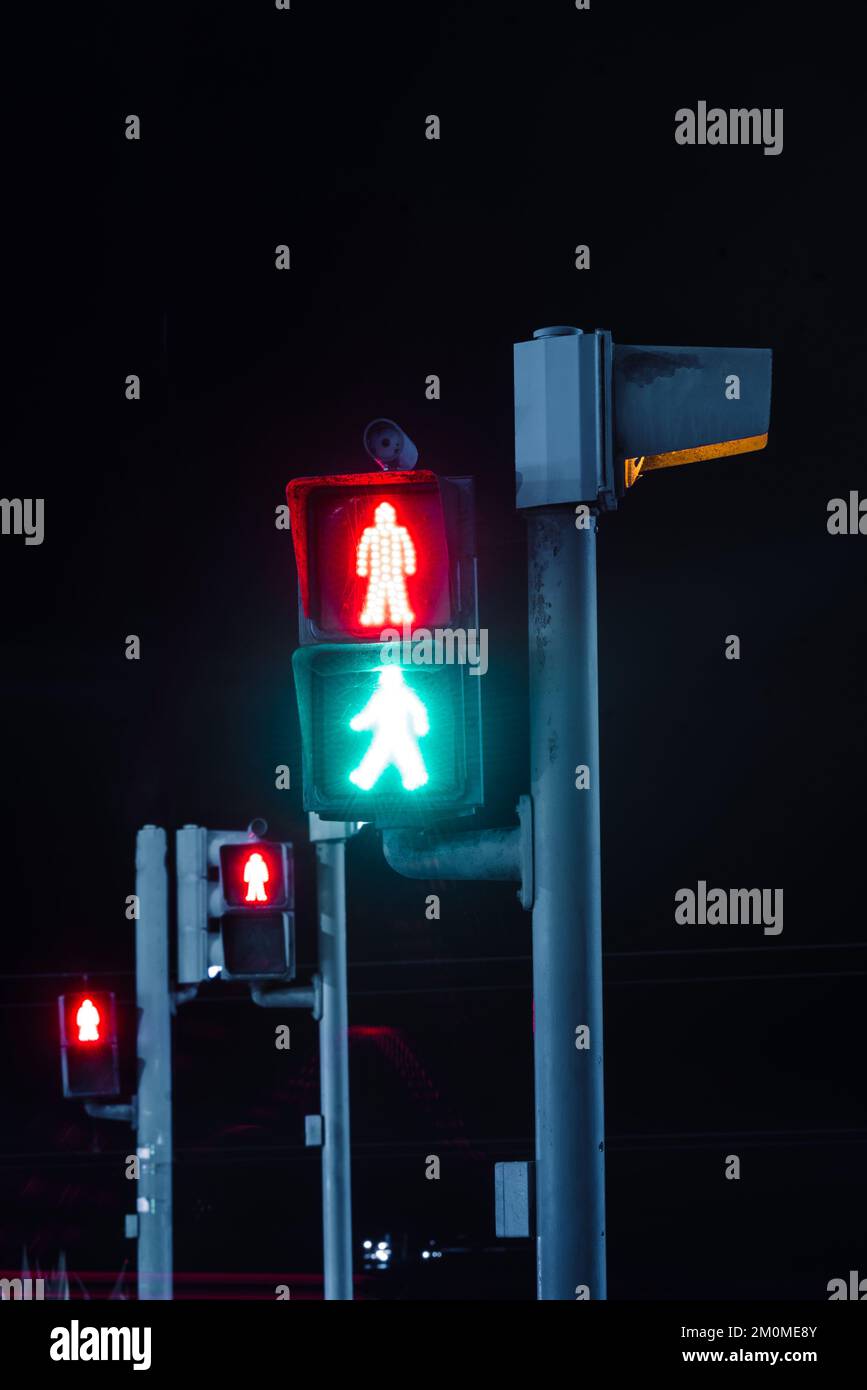 Rotes und grünes Fußgängerübergangssignal bei Langzeitbelichtung bei Nacht Stockfoto