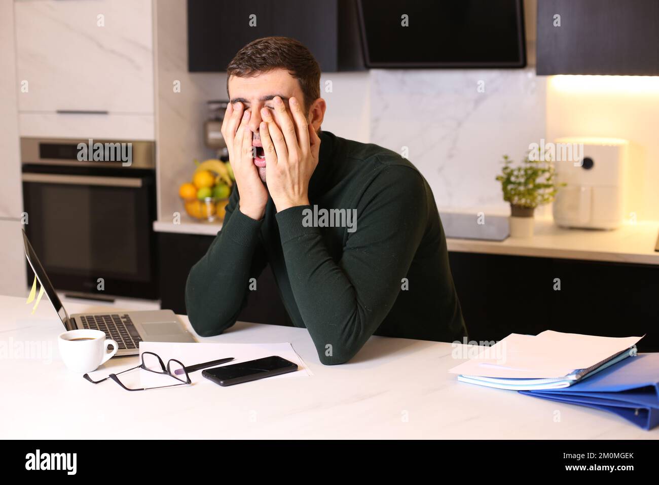 Überarbeiteter Mann im Home Office Stockfoto