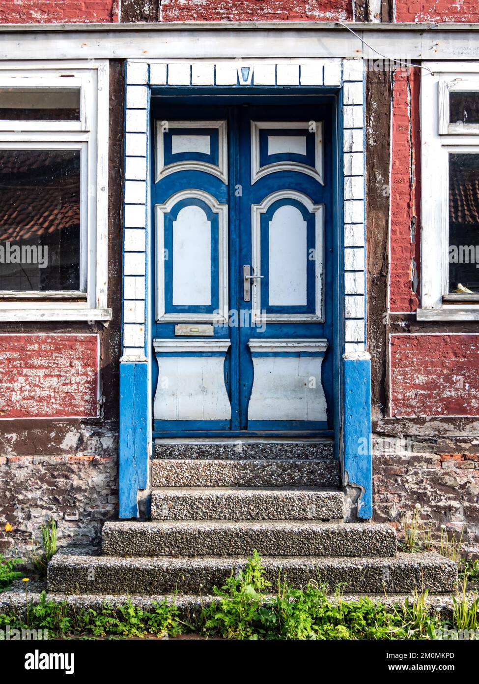 Alte Holztür in Blau und Weiß in einem historischen Fachwerkhaus Stockfoto