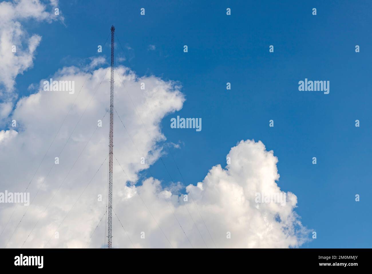 Auf der linken Seite des Bildes befindet sich eine Radioantenne aus Stahlrahmen mit einer Schlinge am Boden. Der Hintergrund ist ein hellblauer Himmel mit Stockfoto