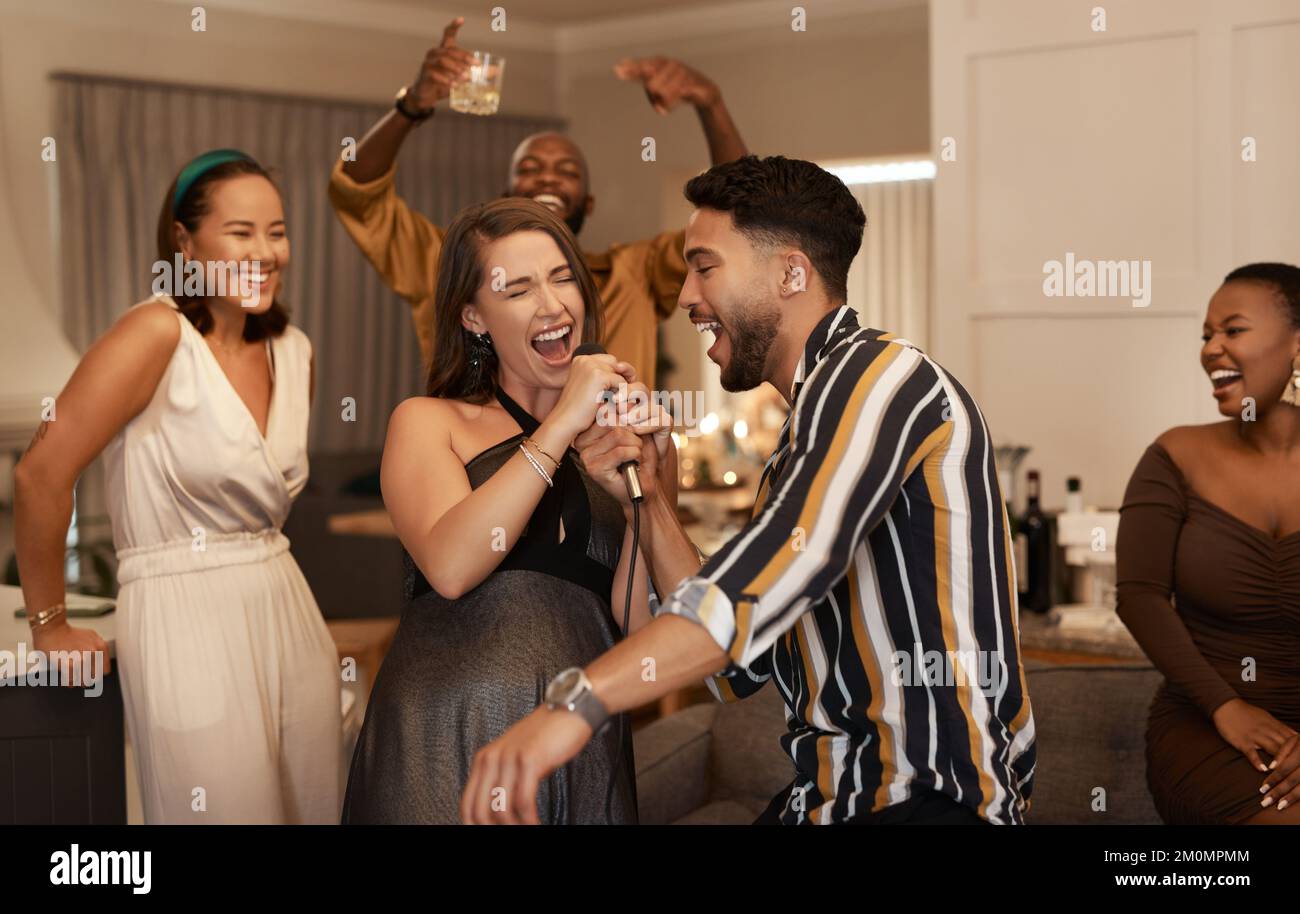 Freunde, Party und Karaoke-Abend im Haus für lustige gesellschaftliche Veranstaltungen oder gemeinsame Feiern zum Neujahrsfest. Glückliche Leute feiern Stockfoto