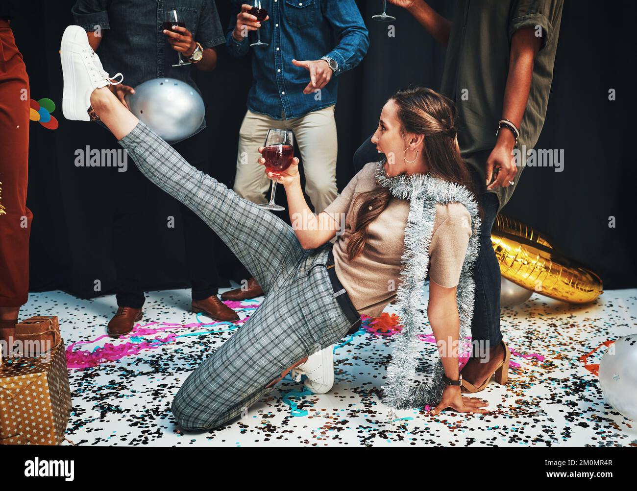 Frau, Tanz und Wein zum Feiern mit Freunden auf dem Boden, mit Konfetti, Alkohol und Tanzbewegungen für Neujahr, Geburtstag oder Weihnachten. Betrunken Stockfoto