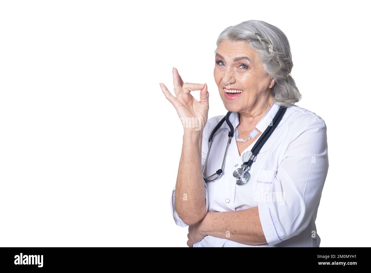 Lächelnde ältere Ärztin zeigt sich ok Stockfoto