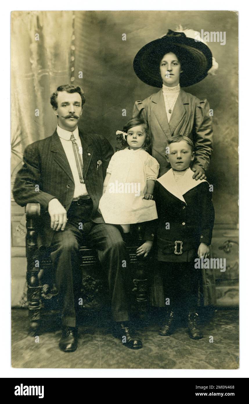 Originale Postkarte aus der Titanic-Ära im Studioporträt einer attraktiven Mittelklasse-Familie, modisch gekleidet, mit 2 kleinen Kindern, aufgenommen am 7. August 1911, im Cooper Brothers Studio, Yonkers, New York. Das Haus der Familie war 92 Park Hill Avenue, Kellinger Street, Yonkers, USA Stockfoto