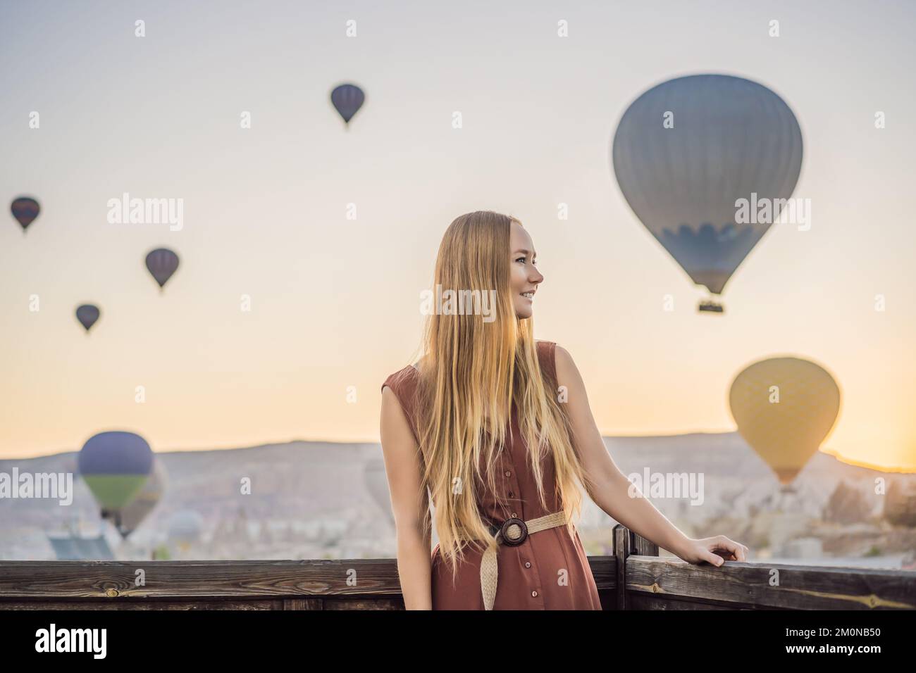 Eine Touristin, die Heißluftballons in Kappadokien, Türkei, ansieht. Happy Travel in Turkey Concept. Eine Frau auf einem Berggipfel, die eine wunderbare Aussicht genießt Stockfoto