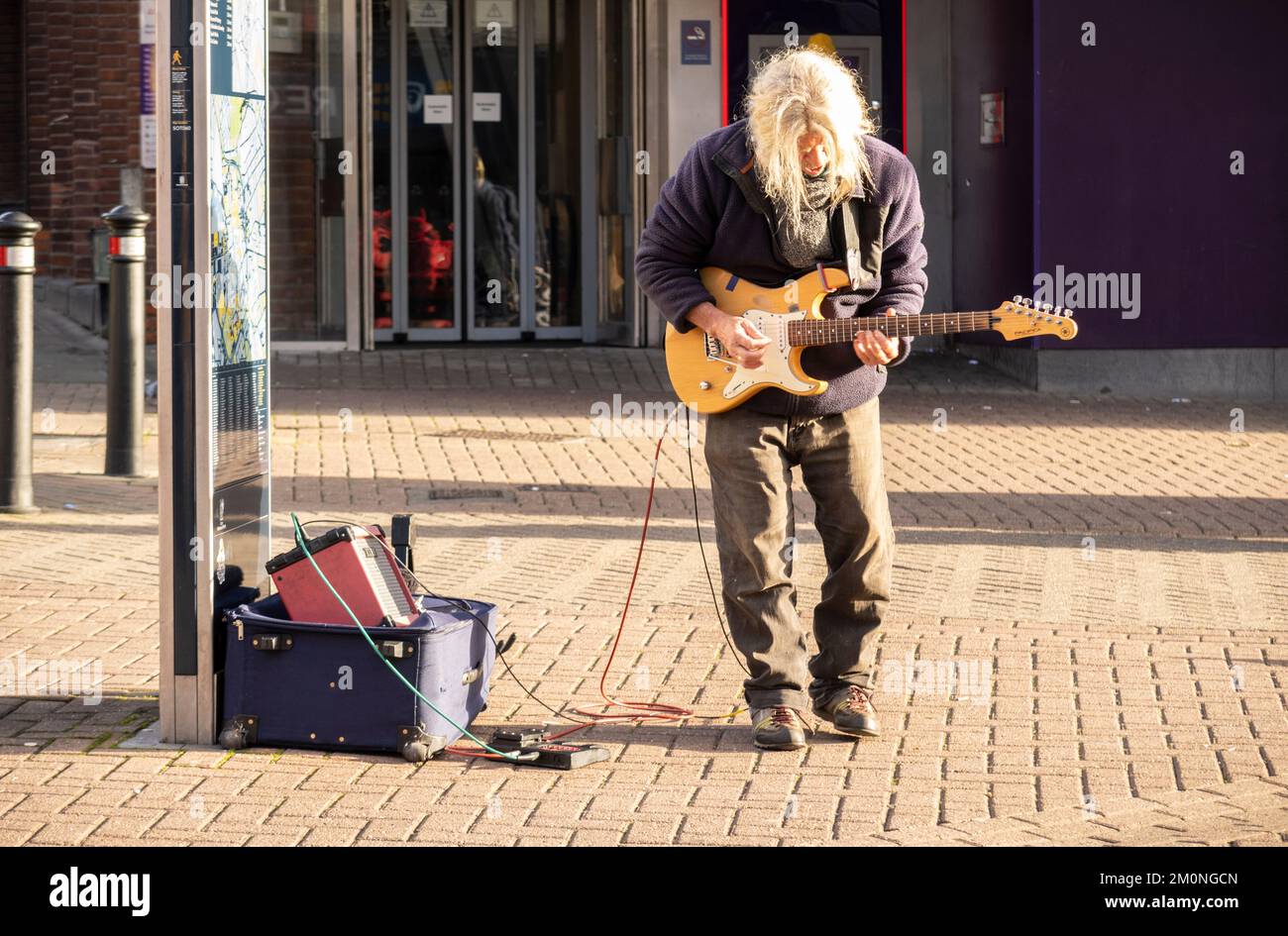 Hanley-Stoke-on-Trent, Staffordshire-Großbritannien 21. April 2022 ein erwachsener, grauhaariger Mann spielt Gitarre und singt auf einer Stadtstraße. Straßenmusiker Stockfoto