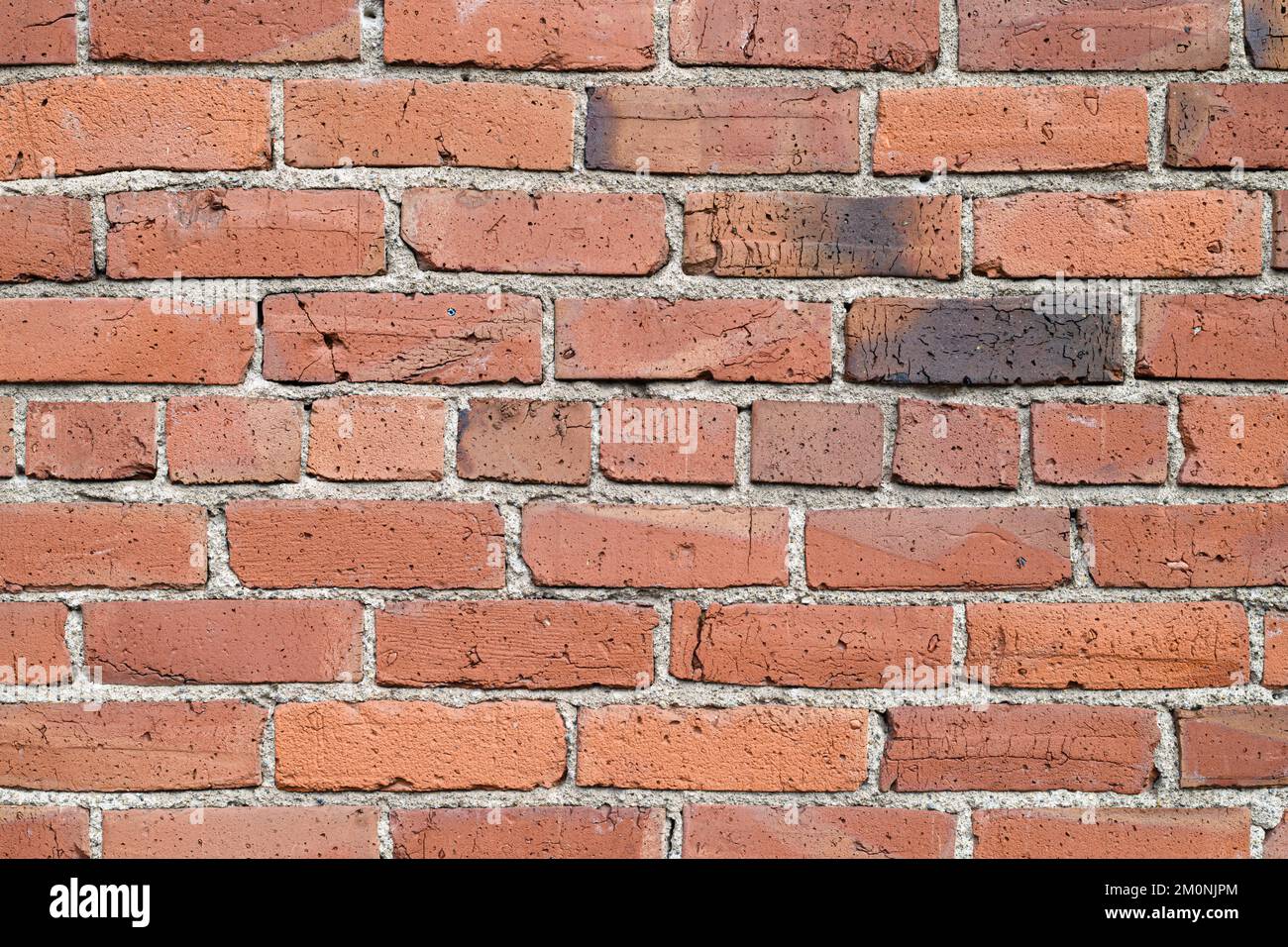 Detail mit alten roten Ziegeln in der Wand mit Zement und Narben des Alters Stockfoto