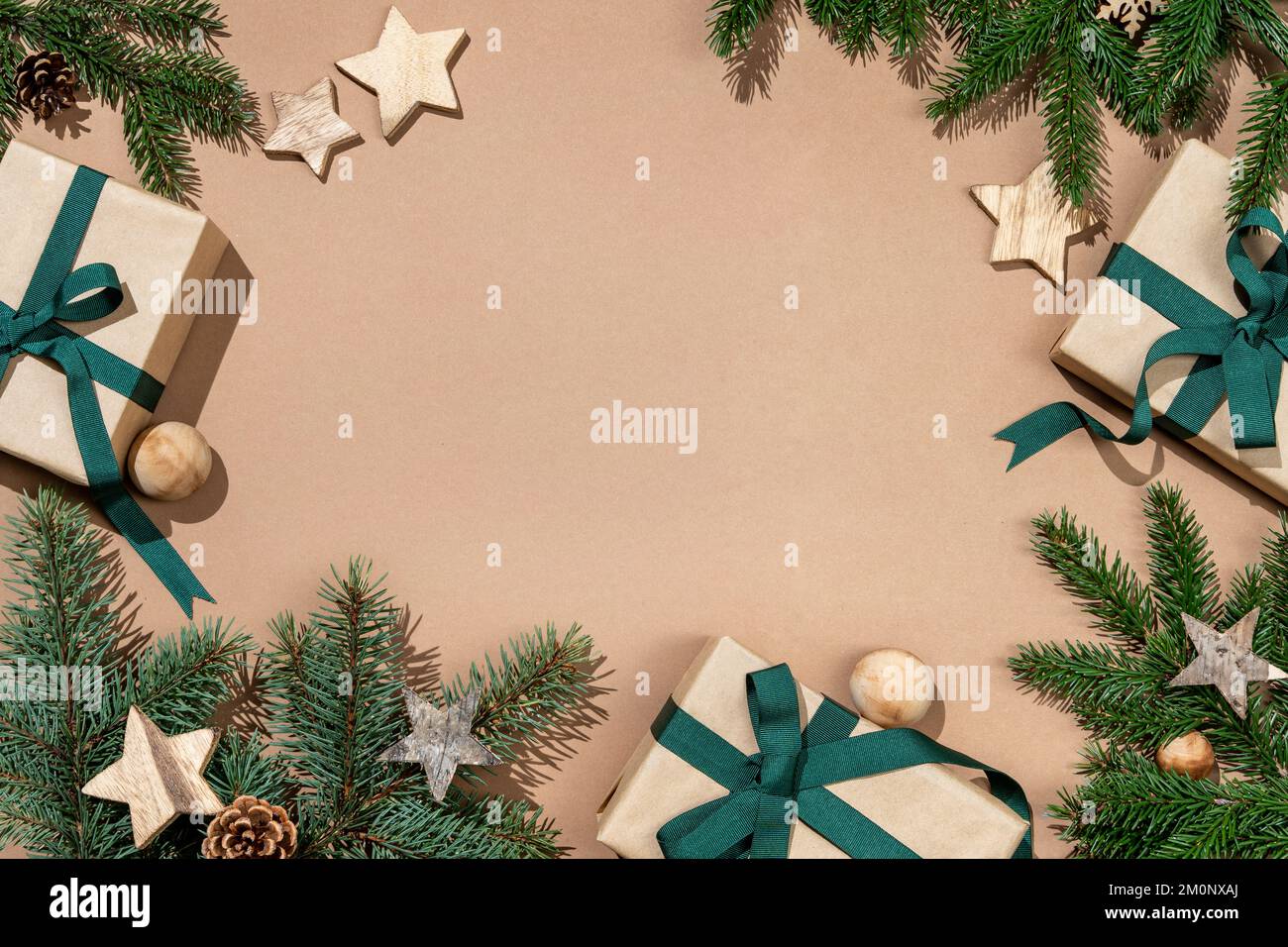 Tannenbäume mit hölzernen Sternen und Geschenkboxen auf beigefarbenem Hintergrund. Merry Christmas und Happy New Year Concept Stockfoto