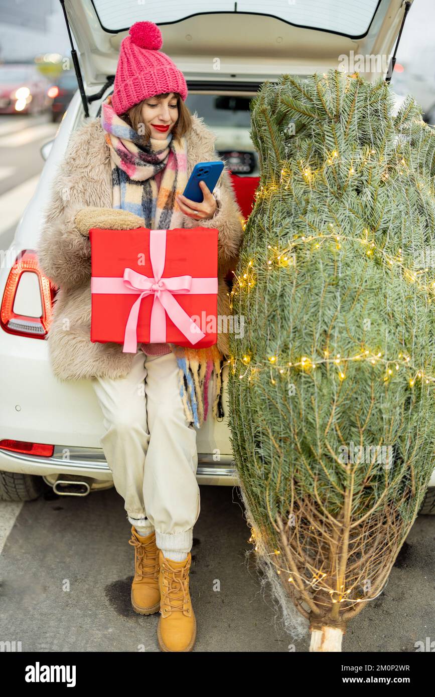 Eine Frau telefoniert, während sie Winterkleidung einkauft Stockfoto