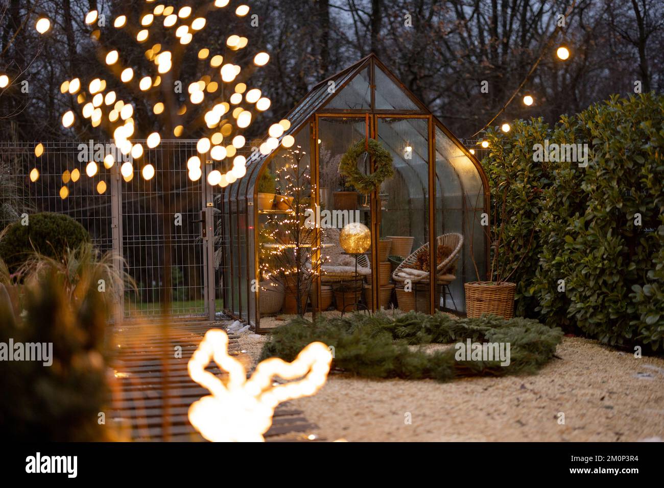 Wunderschöner Hinterhof mit altem Gewächshaus und Weihnachtskranz im Winter Stockfoto