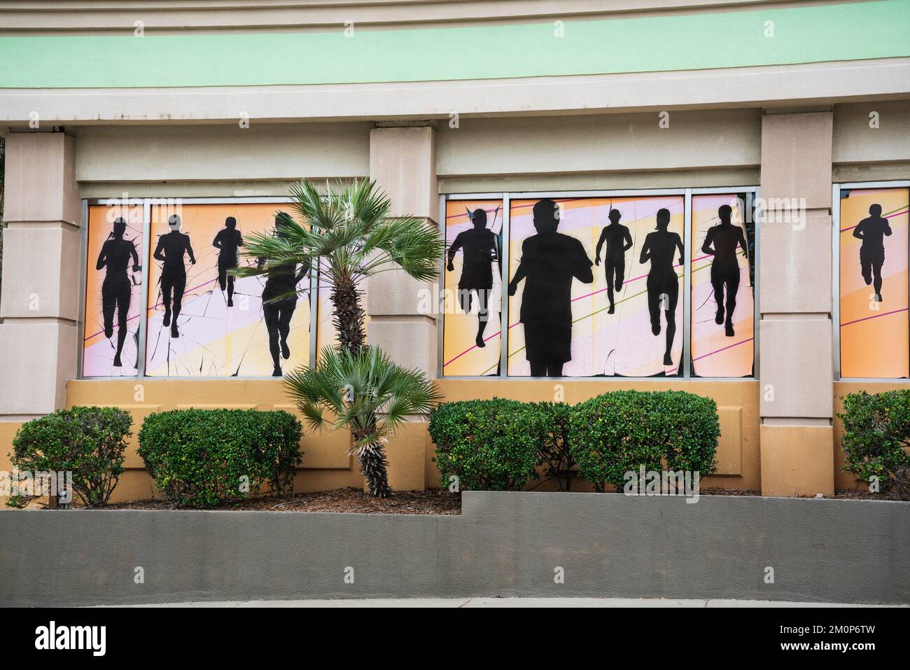 Wandgemälde von Läufern in Silhouette schmücken das Äußere von FIT 2 RUN, Fitness-Training Center in einem Florida Shopping Mall. Stockfoto
