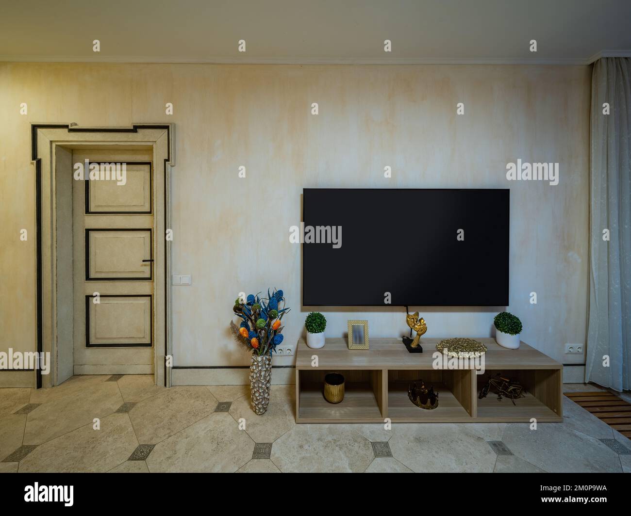 Wohnzimmereinrichtung im Privathaus. Fernseher an der Wand. Geschlossene Tür. Stockfoto