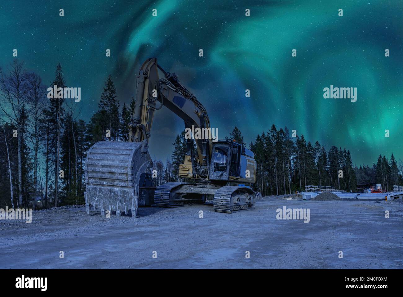Nahaufnahme der Vorderseite des wunderschönen großen gelben Hydraulikbaggers mit großen Schaufelständern unter der frühen Nacht der Aurora Borealis. Nordlichter scheinen über dichten Powe Stockfoto