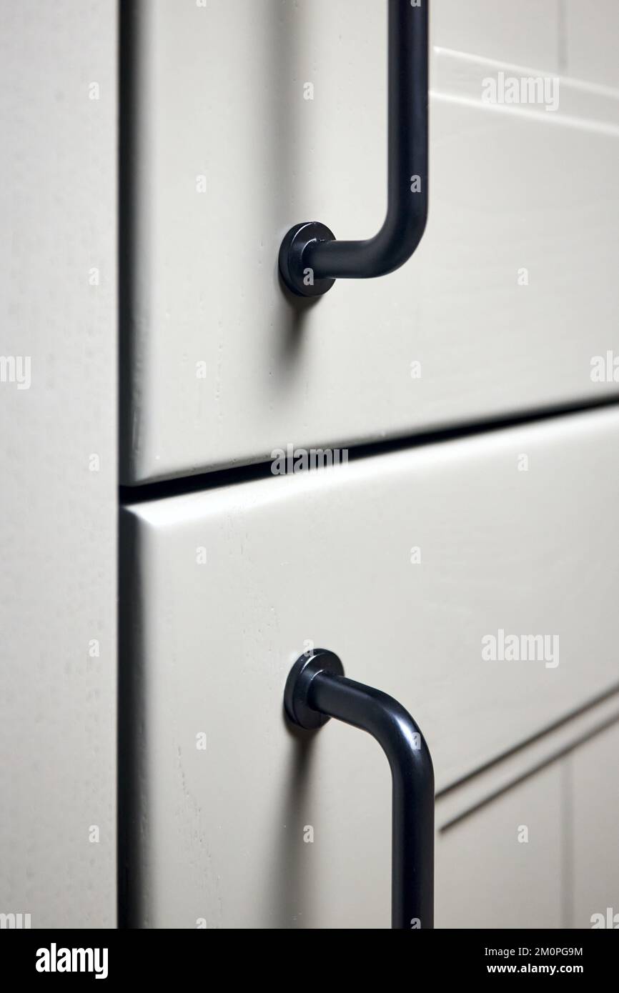 Graue Moos Massivholz lackierte Schranktüren moderner Innenraum mit Türknöpfen schwarze Griffe, Aufbewahrung oder Kleiderschrank mit Metallgriffen geschlossen Stockfoto