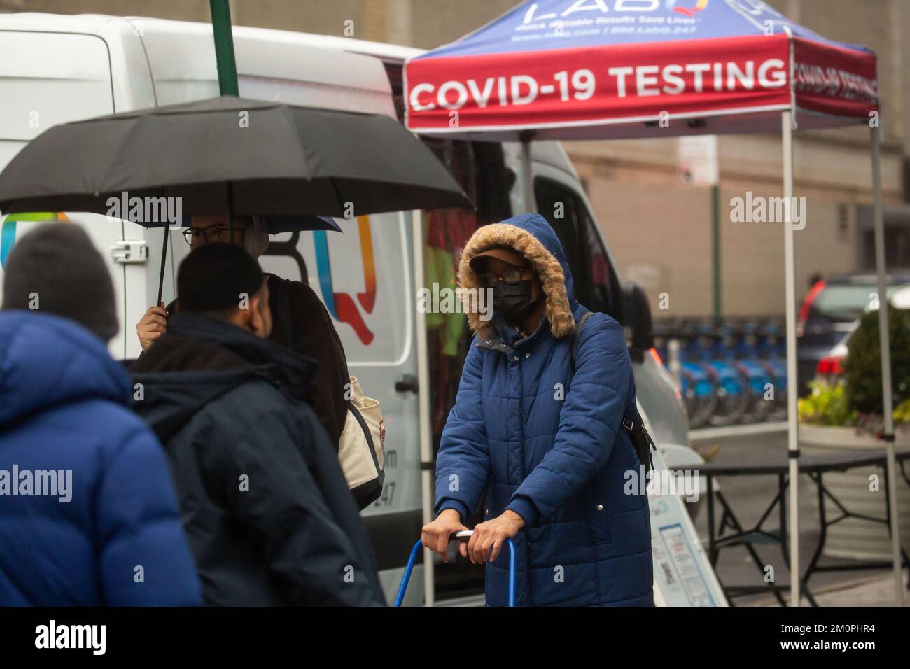 New York, USA. 7.. Dezember 2022. Am 7. Dezember 2022 gehen Menschen an einem COVID-19-Testgelände in New York (USA) vorbei. In den Vereinigten Staaten kommt es zu einer Zunahme von Atemwegserkrankungen wie COVID-19, Grippe und dem Respiratory Syncytial Virus (RSV), wodurch sich die Belastung von Krankenhäusern verschlechtert. Kredit: Michael Nagle/Xinhua/Alamy Live News Stockfoto