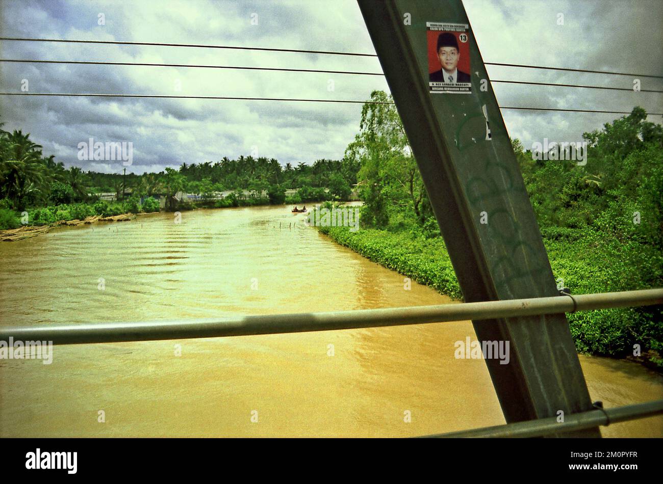 Auf diesem Foto, das 2003 während der Regenzeit in der indonesischen Provinz Banten aufgenommen wurde, befindet sich ein Poster eines Kandidaten für lokale politische Wahlen auf der Struktur einer Brücke, die sich über einen Fluss erstreckt. In dem Wirtschaftsbericht 2022 der APEC (Asia-Pacific Economic Cooperation), der auf der jährlichen Ministertagung der APEC und der Tagung der Wirtschaftsführer im November 2022 in Bangkok veröffentlicht wurde, wird festgestellt, dass die APEC-Mitglieder mit den Herausforderungen der Nachhaltigkeit konfrontiert sind. Und es besteht die dringende Notwendigkeit, grüne Strukturreformen einzuleiten, um dieses Problem anzugehen und eine grüne Erholung von der Konjunkturabschwächung zu fördern. Stockfoto