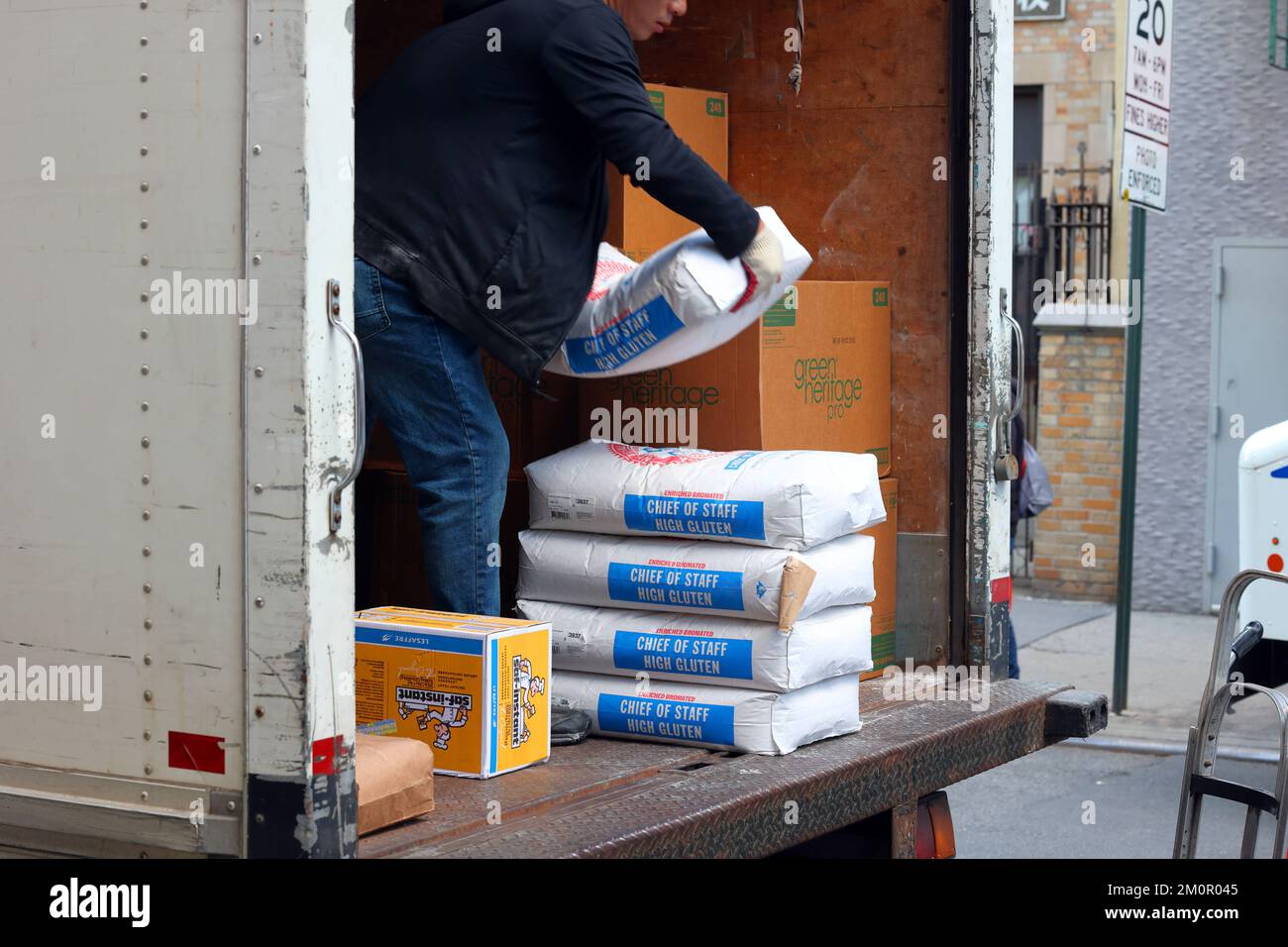 Ein LKW-Fahrer liefert 50lb Beutel Whitehall Commodity Corp, Stabschef, bromiertes weißes Mehl und andere Restaurantmaterialien in NYC. Stockfoto