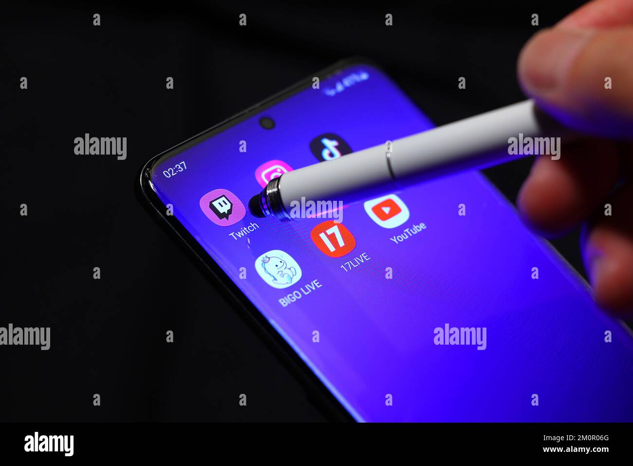 Ein Eingabestift zeigt auf die Twitch tv Livestreaming-App auf einem Smartphone, das von anderen Streaming-Apps umgeben ist. Stockfoto