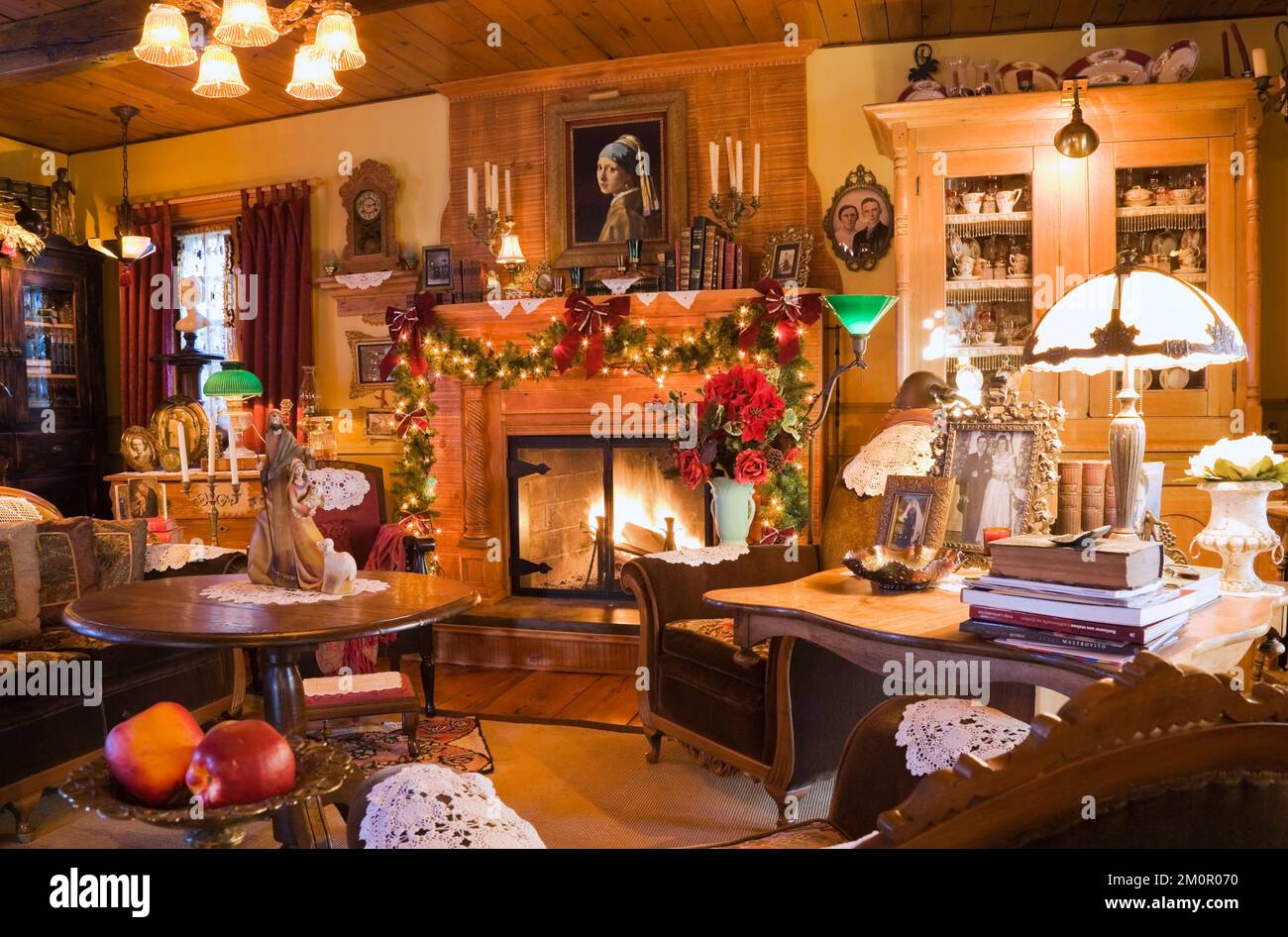 Üppig dekoriertes Wohnzimmer zur Weihnachtszeit im Inneren von 1977 erbauten Nachbau der alten Canadiana Cottage Stil Blockhütte aus dem Jahr 1800er. Stockfoto