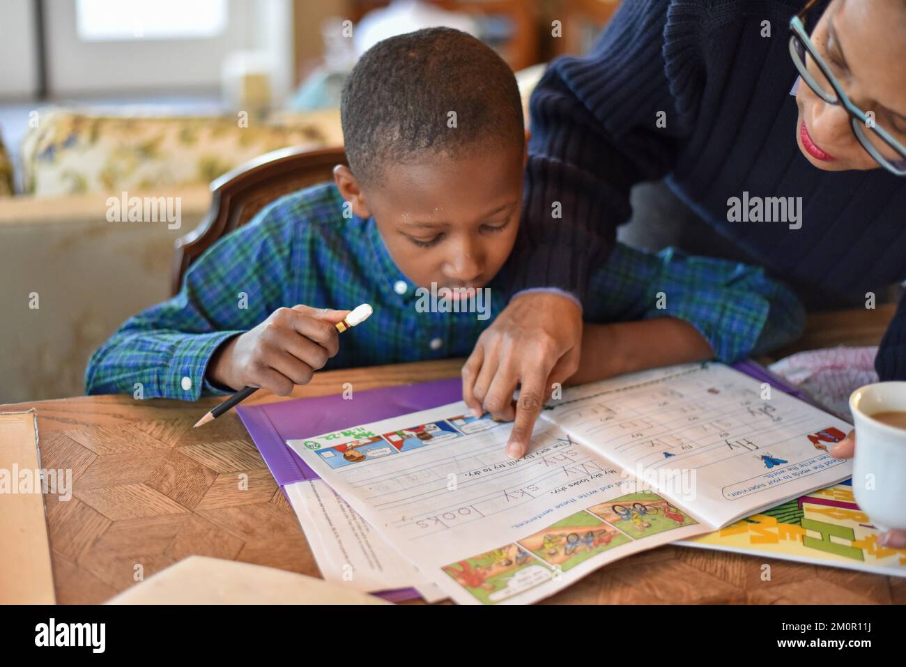 Der kleine Junge wird zu Hause unterrichtet, macht Hausaufgaben und lernt neue Dinge und neue Lehrmethoden Stockfoto
