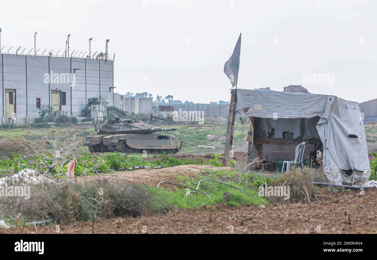 Gaza, Palästina. 07.. Dezember 2022. In der Nähe israelischer Bagger und Bulldozer ist ein israelischer Merkava-Kampfpanzer stationiert, der die Überreste des Karni-Handelsübergangs in der Nähe der Grenze zu Gaza abriss, als Israel beschloss, eine Sicherheitsbarriere am Standort des seit langem stillgelegten Terminals zu erweitern. Kredit: SOPA Images Limited/Alamy Live News Stockfoto