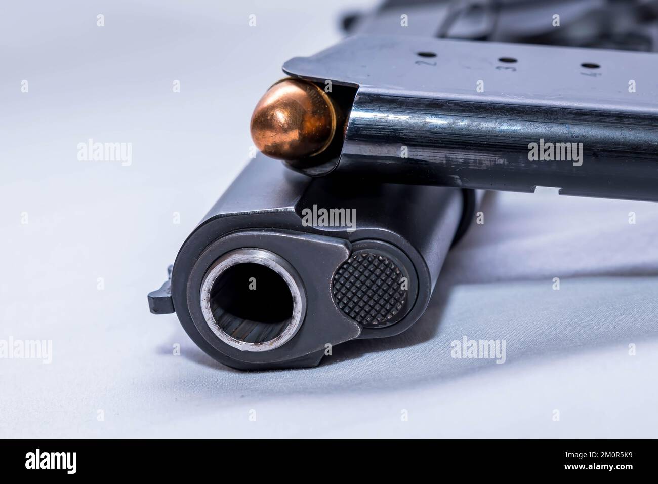 Eine schwarze 45 Kaliber Pistole mit einem beladenen Magazin auf weißem Hintergrund Stockfoto