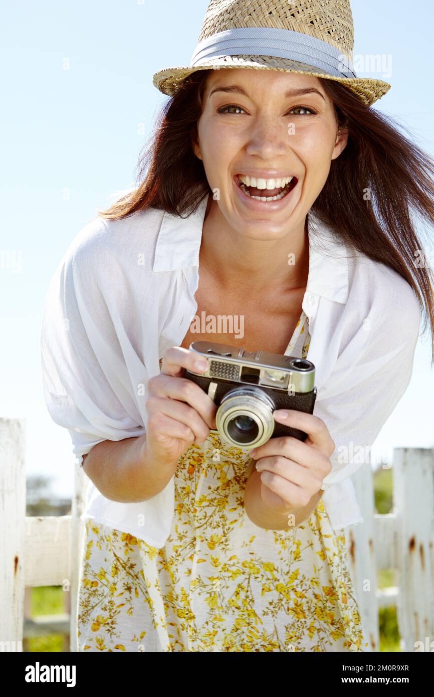 Sagen Sie Cheese. Eine wunderschöne junge Frau, die draußen mit einer alten Kamera steht. Stockfoto Sagen Sie Cheese. Eine wunderschöne junge Frau, die draußen mit einer alten Kamera steht. Stockfoto