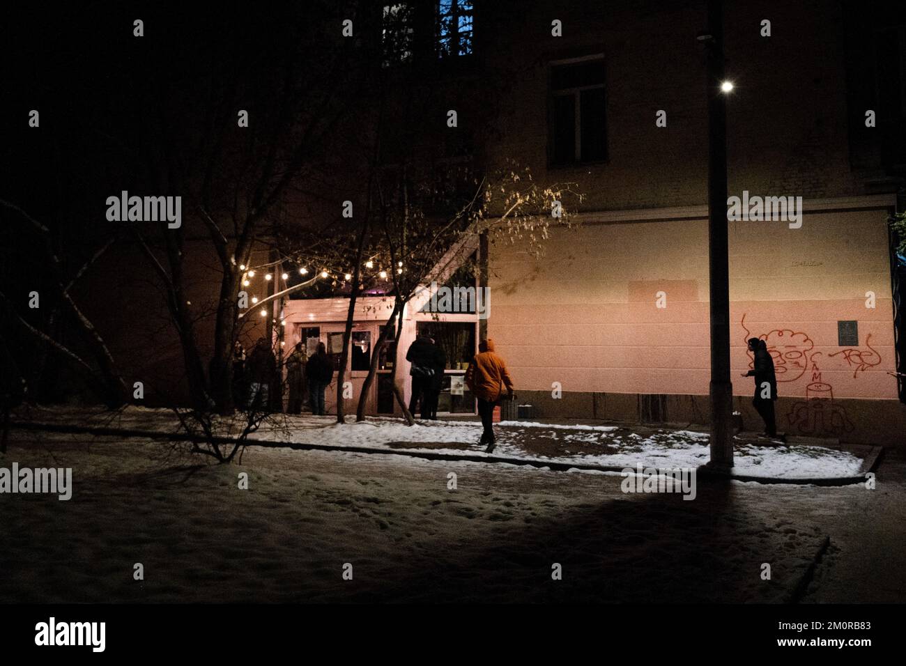 Kiew, Ukraine. 01.. Dezember 2022. Barbesucher wurden gesehen, wie sie in eine schwach beleuchtete Bar in Kiew gingen. Die Einwohner Kiews müssen diesen Winter nicht nur um die Kälte kämpfen, sondern kämpfen auch um einen ständigen Stromausfall aufgrund des russischen Angriffs auf das Stromnetz. (Foto: Ashley Chan/SOPA Images/Sipa USA) Guthaben: SIPA USA/Alamy Live News Stockfoto