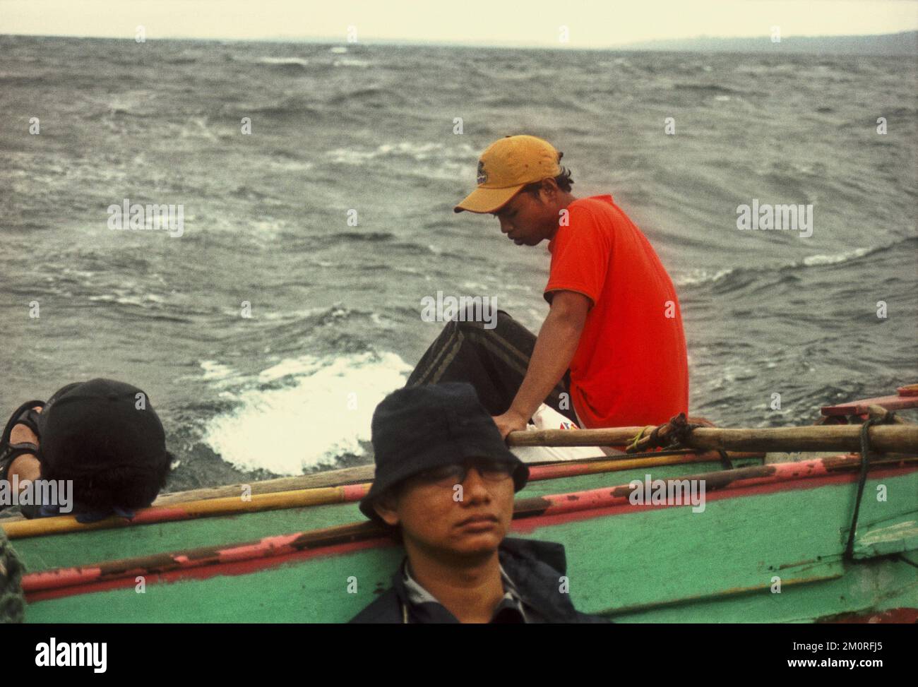 Passagiere und Schiffsbesatzungen schlafen und sitzen auf einem gemieteten Boot, das auf der Sunda-Straße inmitten schlechter Wetterbedingungen segelt und nach dem Verlassen von Peucang Island, einem Teil des Ujung Kulon Nationalparks in Pandeglang, Banten, Indonesien, in die Küstenstadt Sumur fährt. Stockfoto