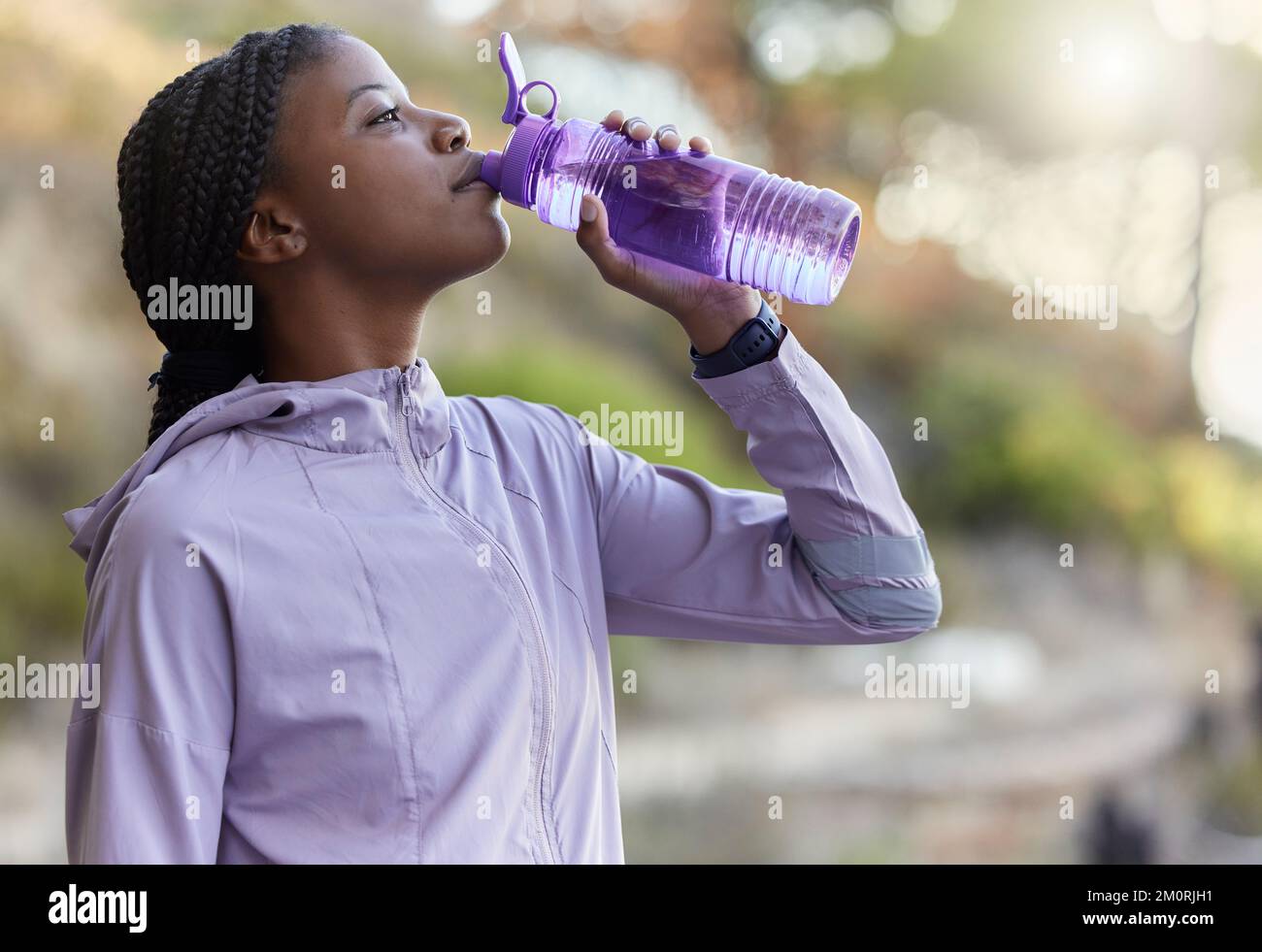 Schwarze Läuferin, Trinkwasserflasche oder Ruhe für Hydration, Wellness und Gesundheit im Sommertraining. Frau, Laufen und Wasser für Sport trinken Stockfoto