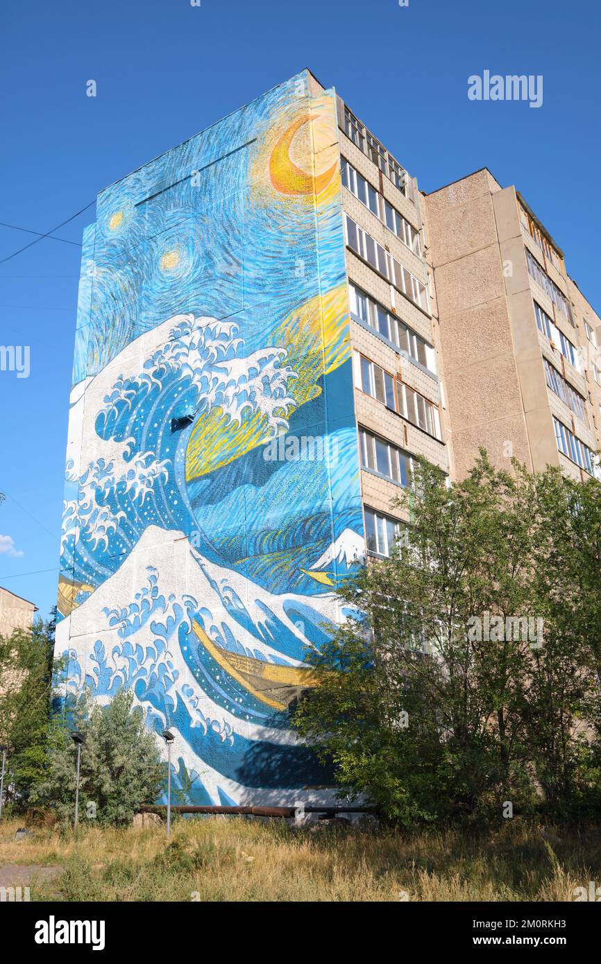 Ein riesiges gemaltes Wandgemälde am Ende eines großen Apartmentgebäudes, das eine Kombination aus Van Goghs Sternennacht und Hokusais Welle vor Kanagawa darstellt. ICH Stockfoto
