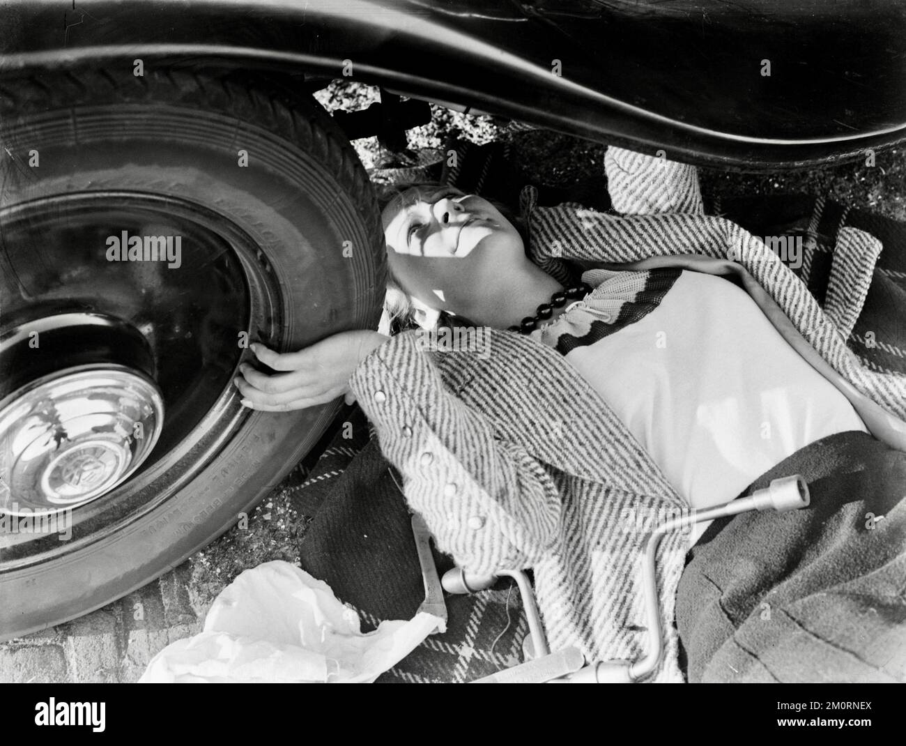 Willem van de Poll - Modell Eva Waldschmidt schaut unter das Auto - 1933 Stockfoto
