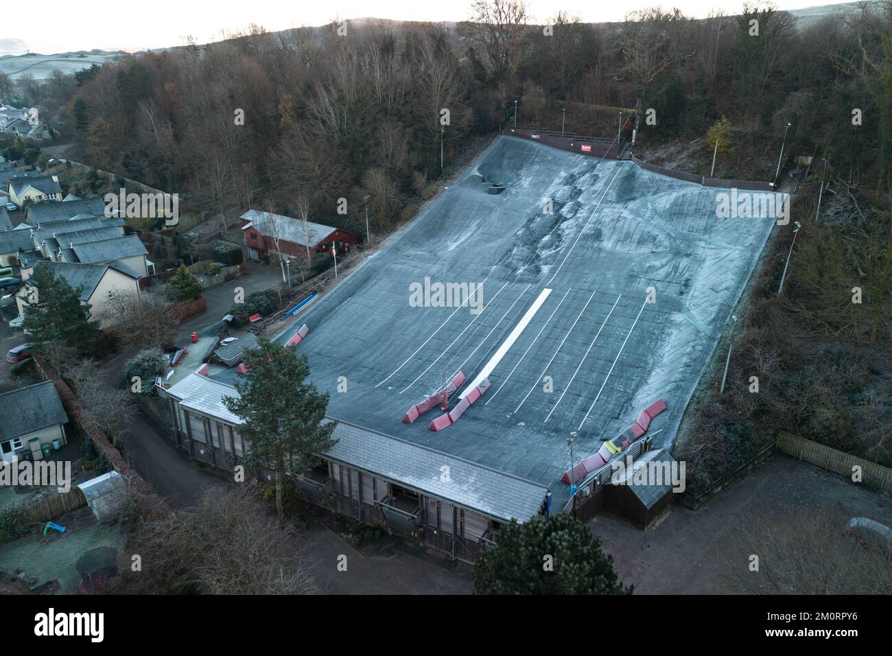 Kendal, Cumbria, 8. Dezember 2022. Gefriertemperaturen von -4 Grad Celsius treffen über Nacht auf Kendal in Cumbria, was einen harten Frost und eiskalten Nebel über der historischen Stadt verursachte. Als die Sonne über den Bergen aufging, wurde Kendal Castle in goldenes Licht getaucht. Die trockene Skipiste hat ein winterliches Aussehen, da das normalerweise schwarze Material weiß wurde und die Windschutzscheiben des Autos mit Eis bedeckt waren, nachdem der Troll von Trondheim viele Teile Großbritanniens getroffen hatte. Quelle: Stop Press Media/Alamy Live News Stockfoto