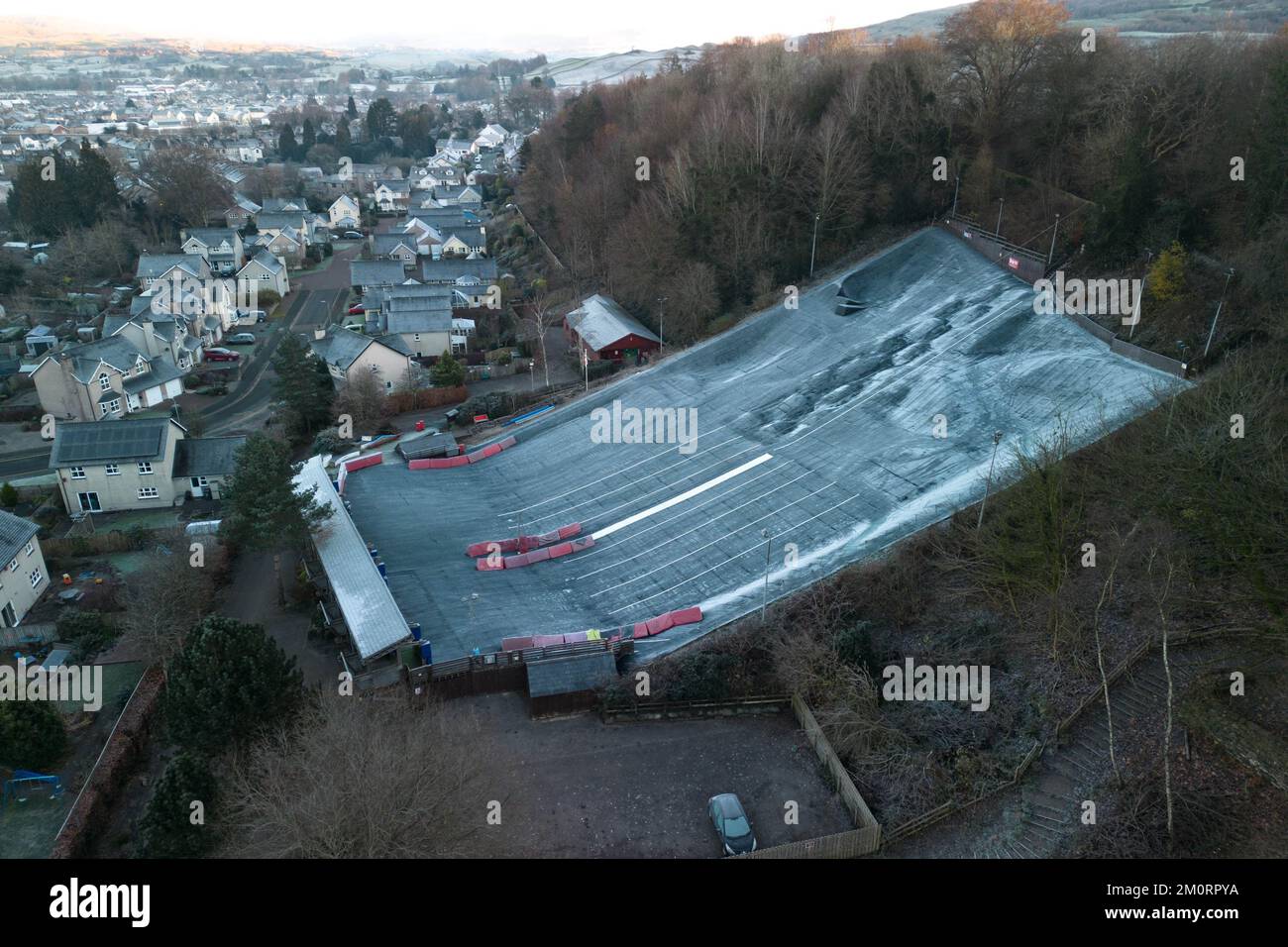 Kendal, Cumbria, 8. Dezember 2022. Gefriertemperaturen von -4 Grad Celsius treffen über Nacht auf Kendal in Cumbria, was einen harten Frost und eiskalten Nebel über der historischen Stadt verursachte. Als die Sonne über den Bergen aufging, wurde Kendal Castle in goldenes Licht getaucht. Die trockene Skipiste hat ein winterliches Aussehen, da das normalerweise schwarze Material weiß wurde und die Windschutzscheiben des Autos mit Eis bedeckt waren, nachdem der Troll von Trondheim viele Teile Großbritanniens getroffen hatte. Quelle: Stop Press Media/Alamy Live News Stockfoto