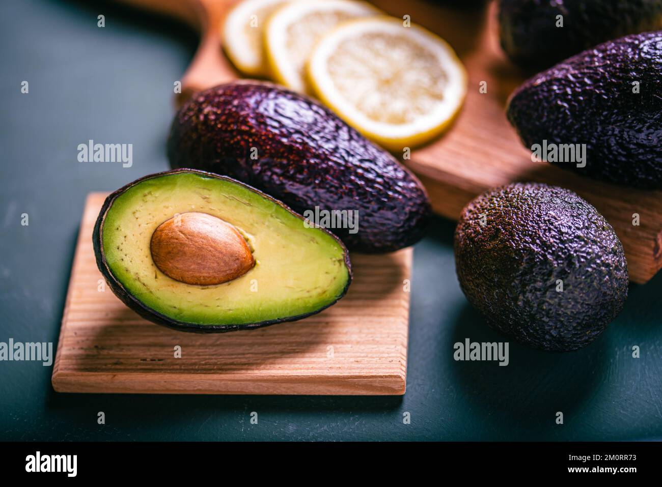 Frische Avocado- und Zitrusscheiben auf dem Schneidebrett. Avocado in zwei Hälften geschnitten Stockfoto