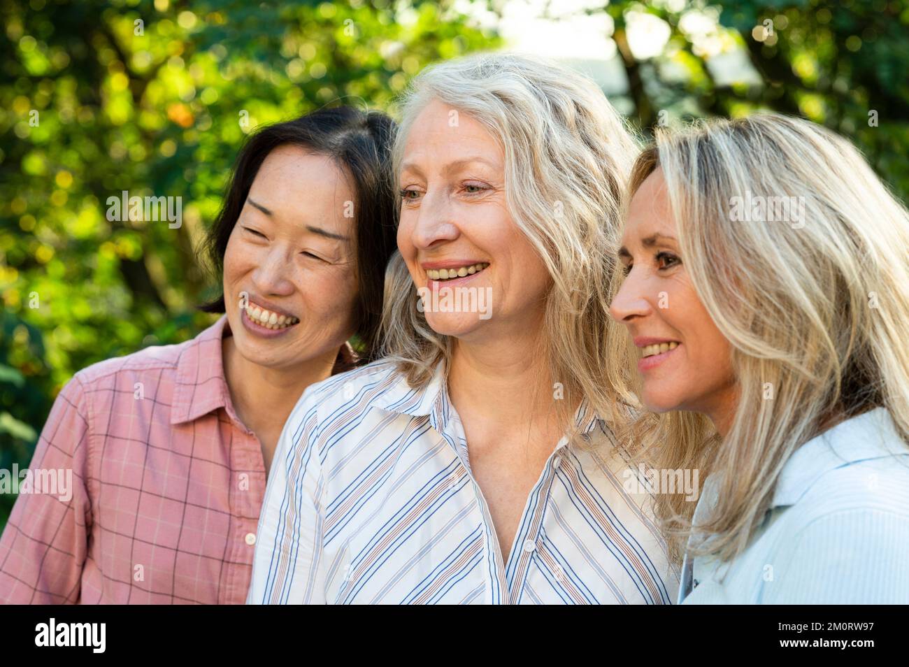 Eine Gruppe von verschiedenen, lebenslangen Freundinnen posiert für Fotos im Freien Stockfoto