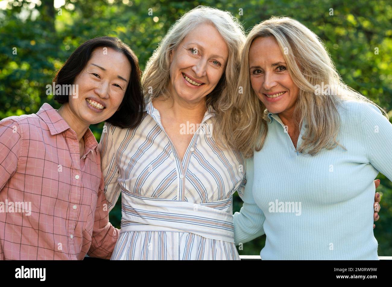Drei ältere Frauen posieren zusammen für Gruppenfotos im Freien Stockfoto