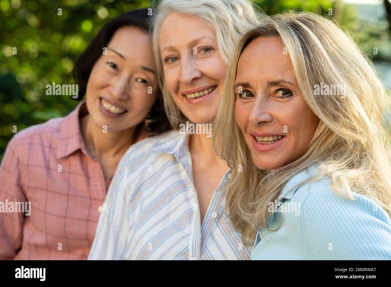 Drei ältere Frauen posieren zusammen für Gruppenfotos im Freien Stockfoto