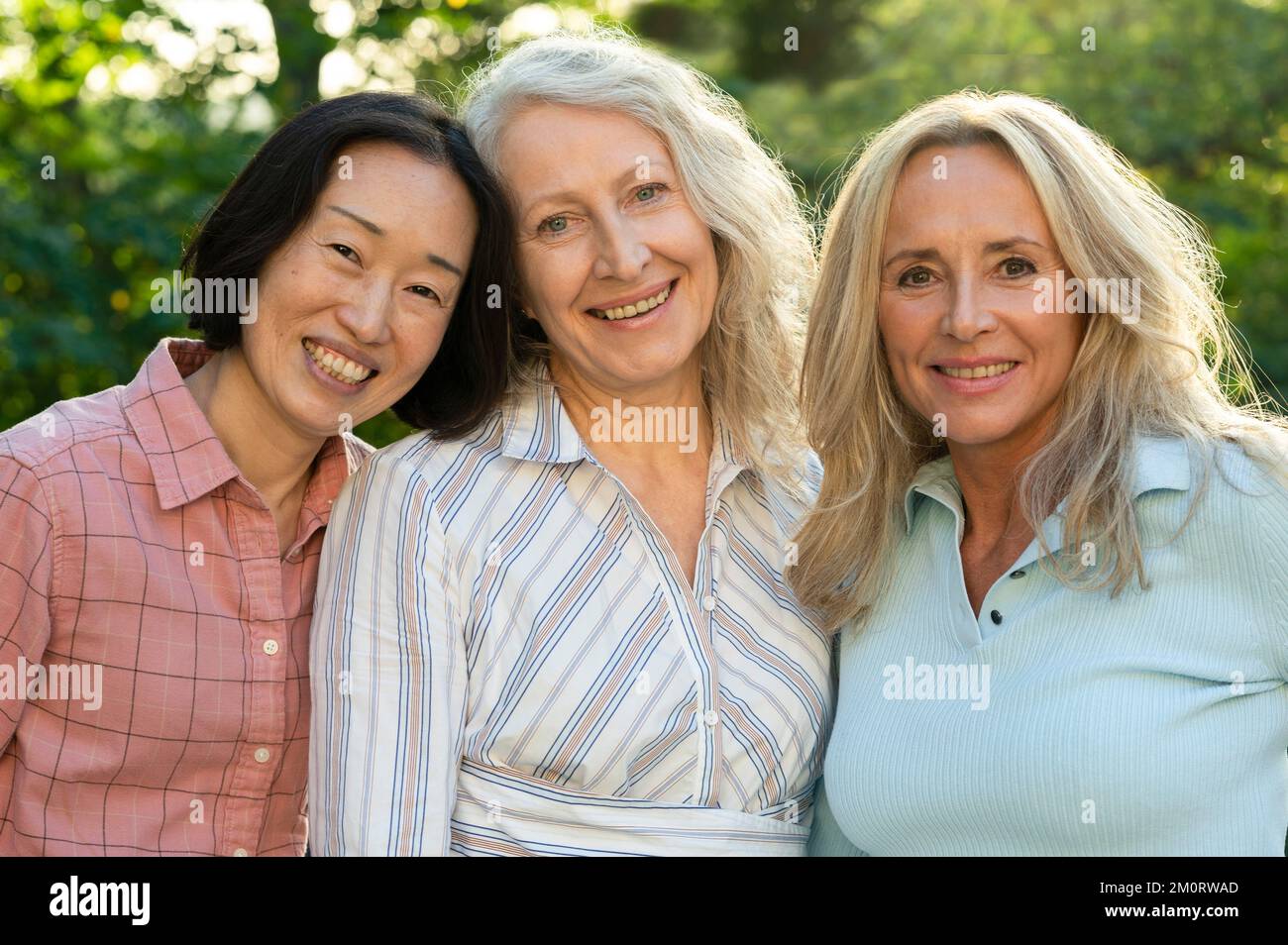 Drei ältere Frauen posieren zusammen für Gruppenfotos im Freien Stockfoto