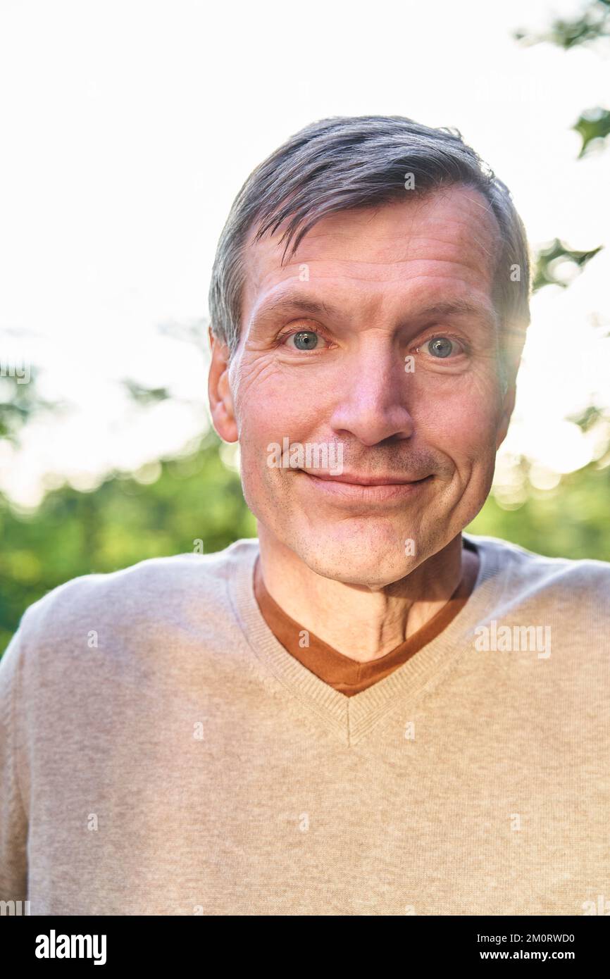 Smiling senior man looking at the camera while standing outdoors Stockfoto