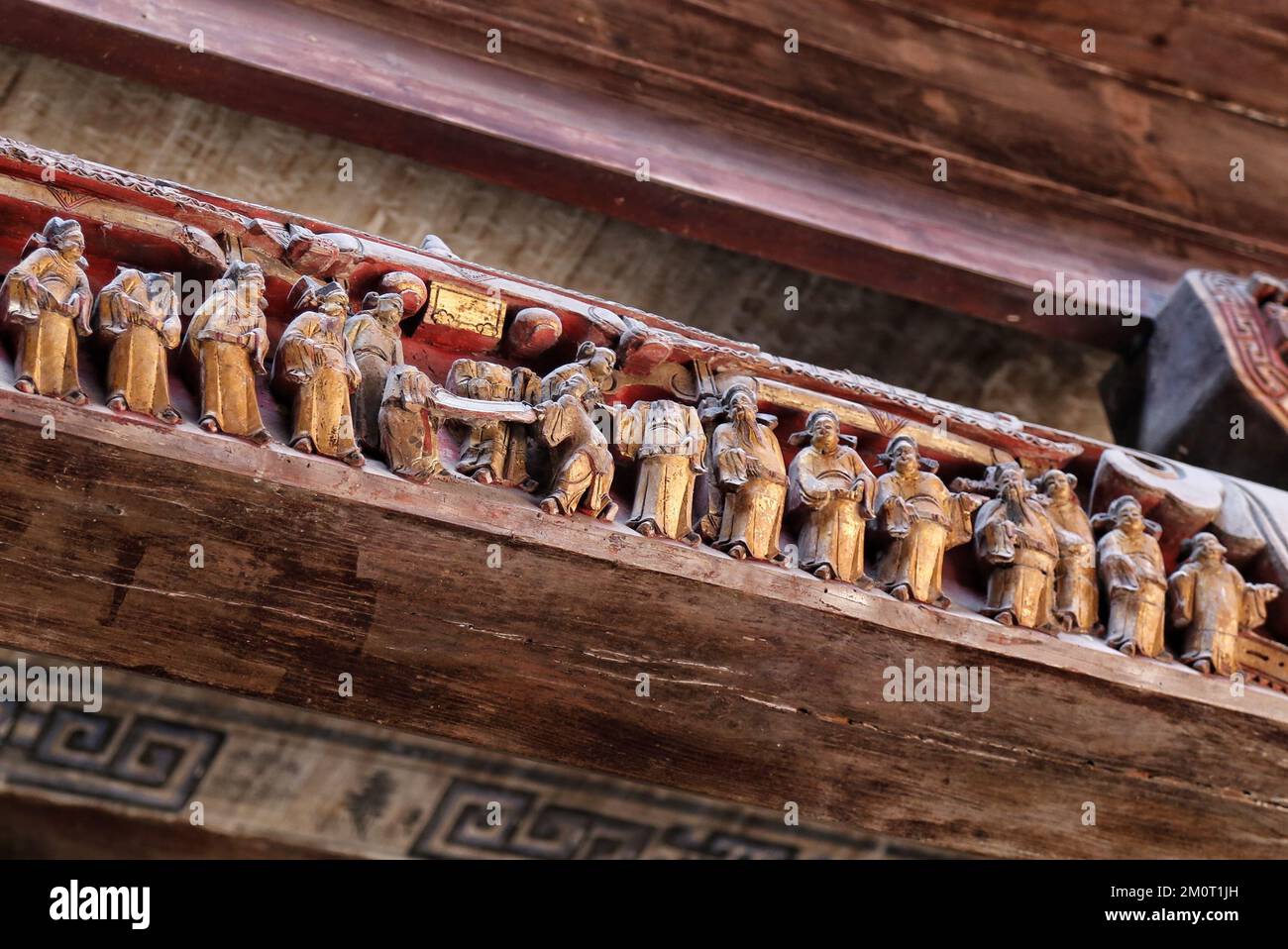 Eine Nahaufnahme der Holzstiche von Menschen auf einem Gebäude Stockfoto